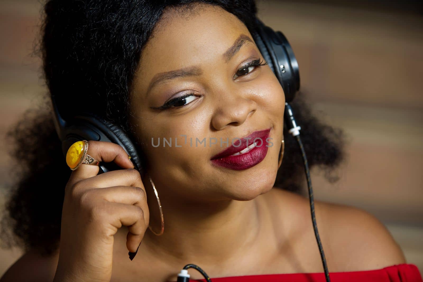 young girl standing with headphones listening to music smiling.