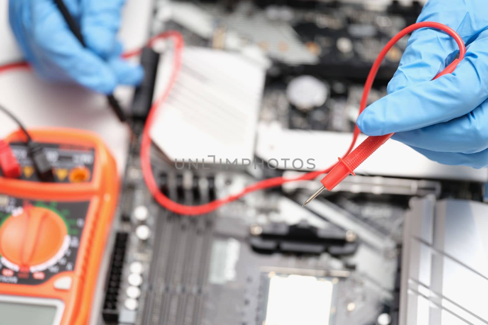 Technician using voltmeter to measure voltage on computer motherboard. Computer equipment repair and upgrade and technology