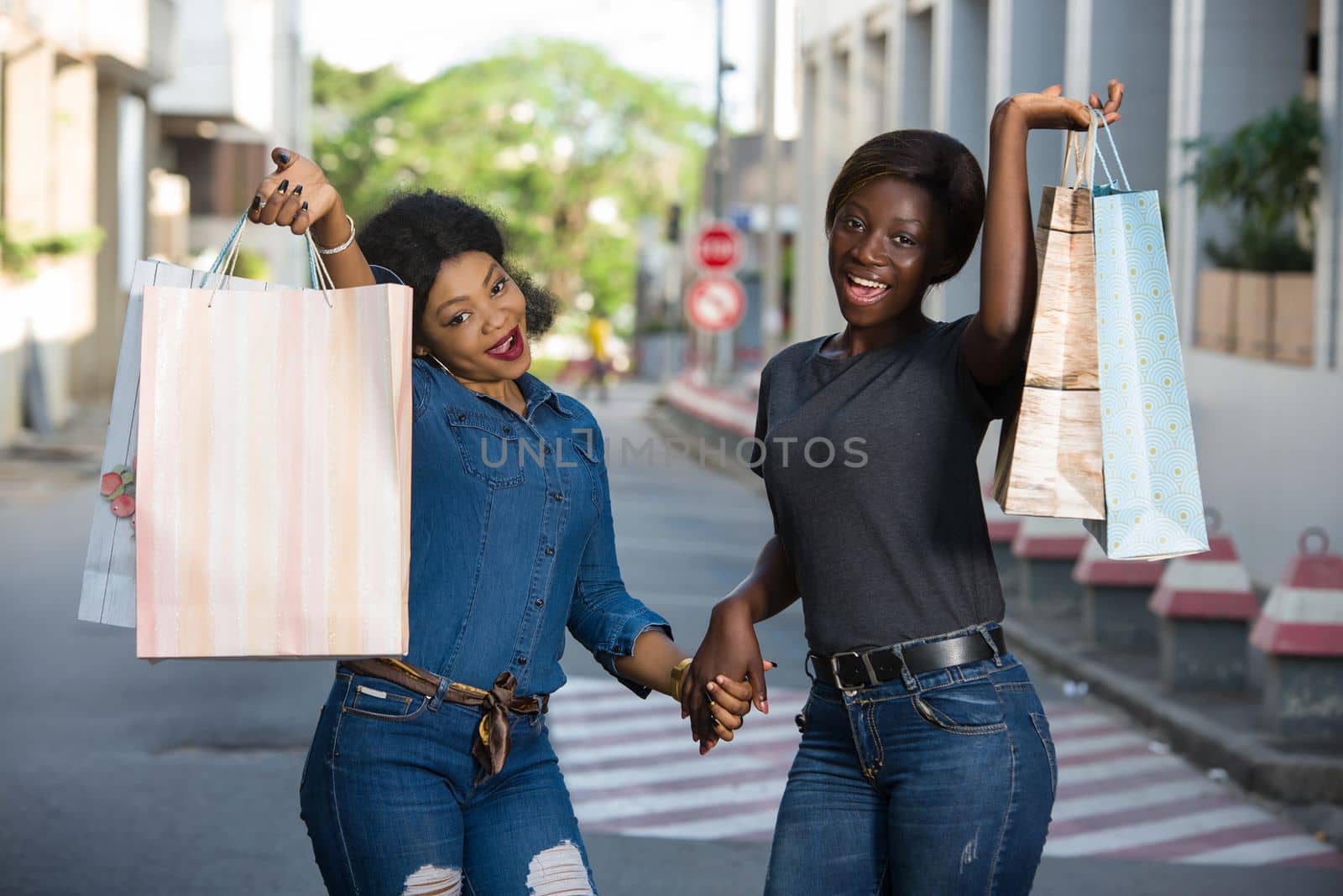 two happy women with shopping bag in town by vystek