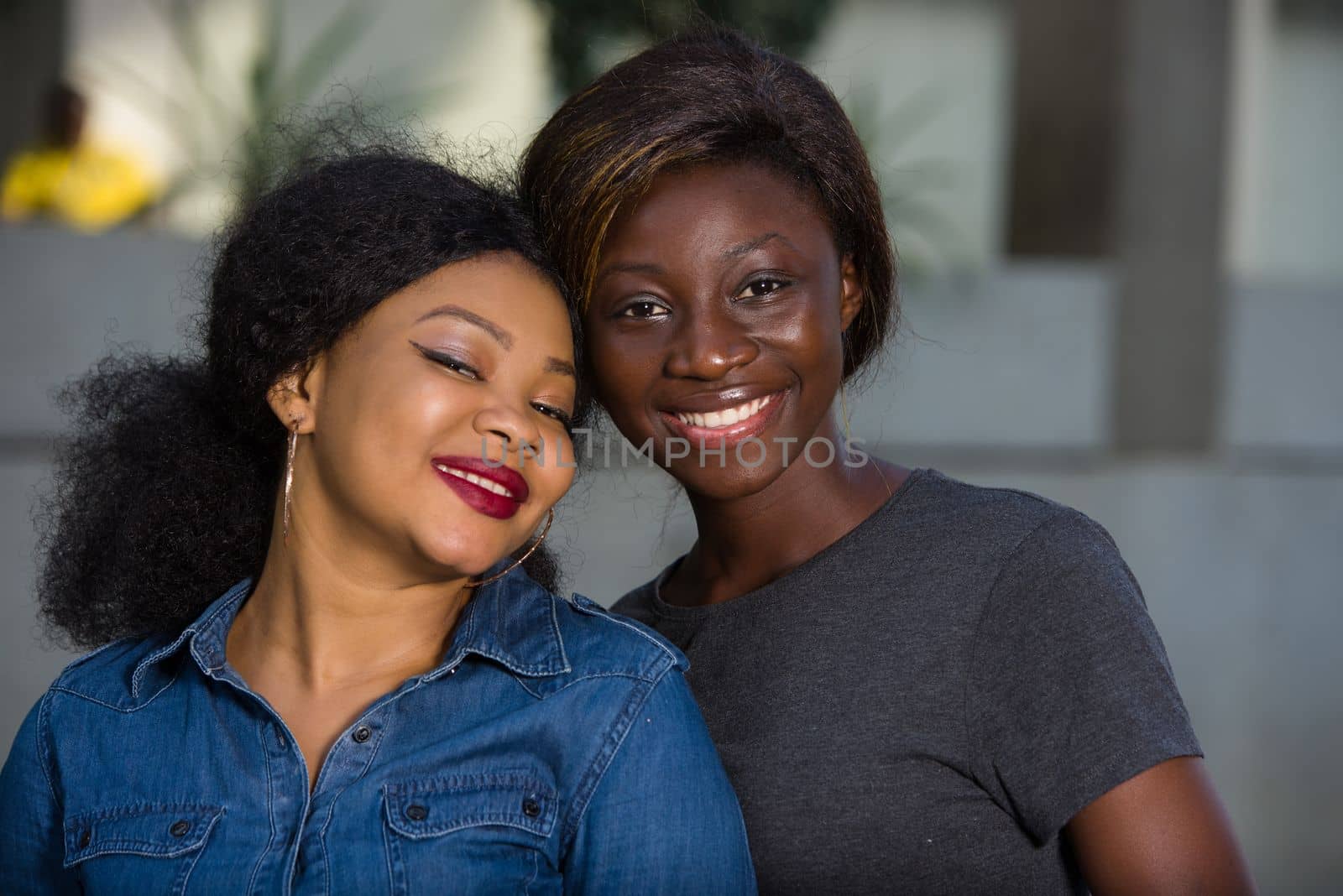 portrait of two women smiling and happy laughing and standing together outdoors