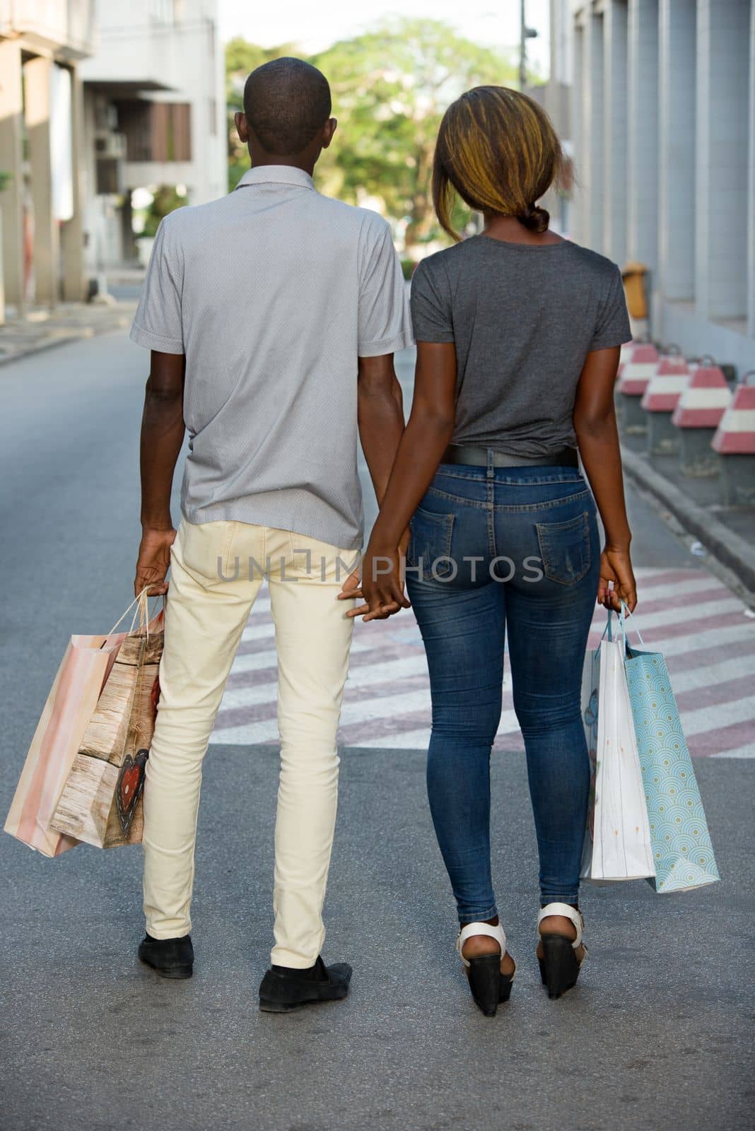 Portrait of a happy couple with shopping bags walking together in city.