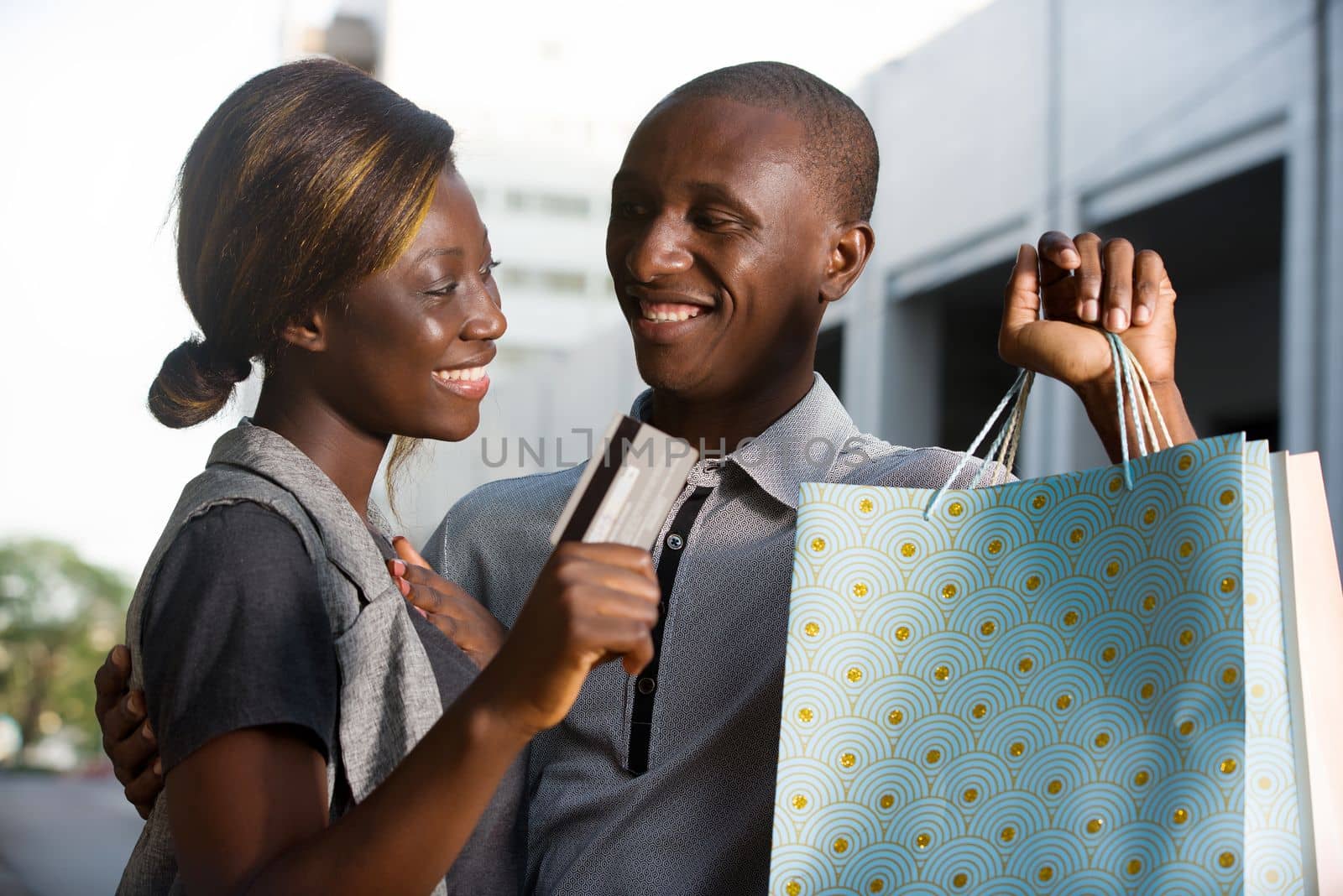 young happy couple holds shopping bags with a credit card out.Concept of shopping and free time.