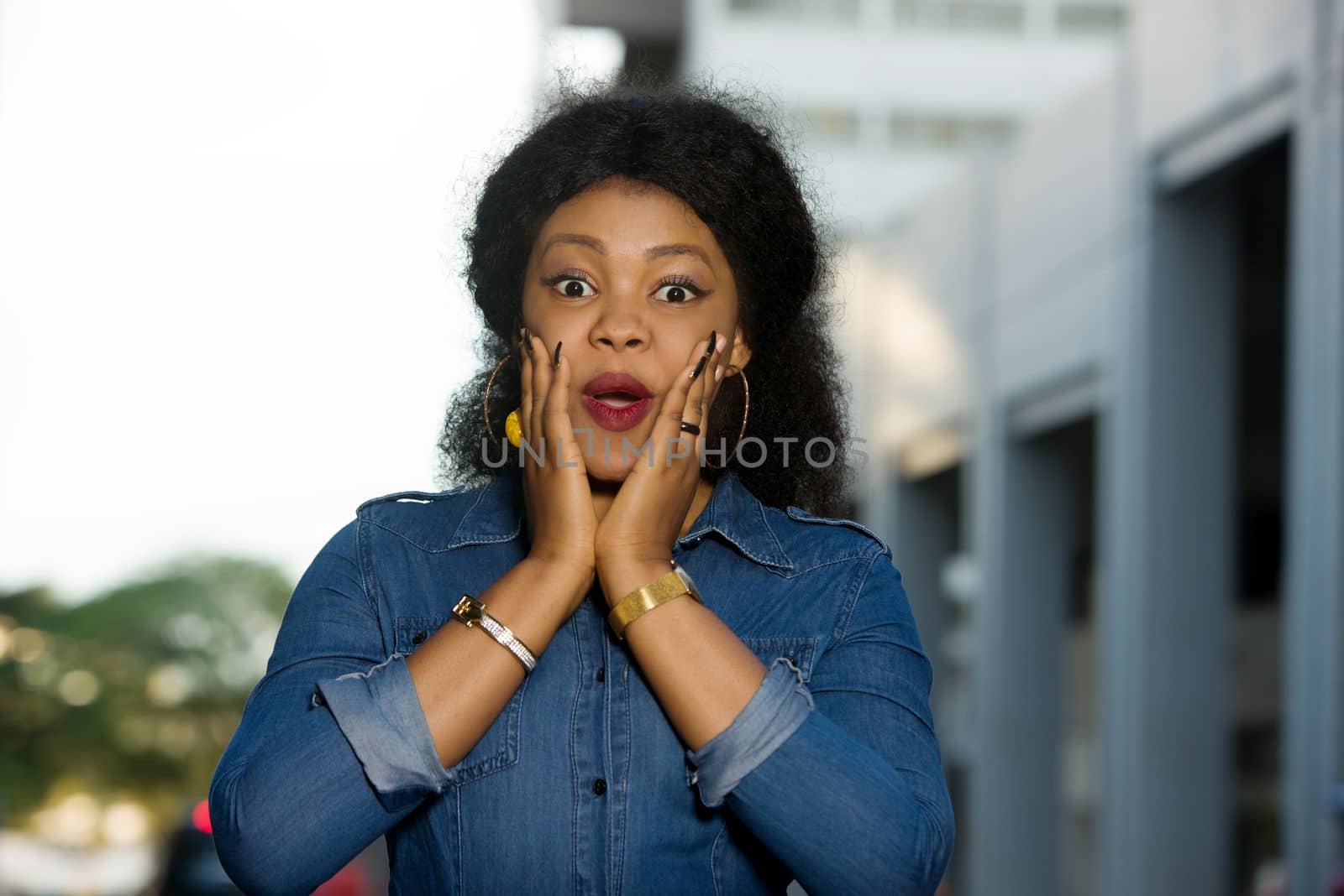 Young woman surprised in the street because of some news. She walks in the street and has the good mood