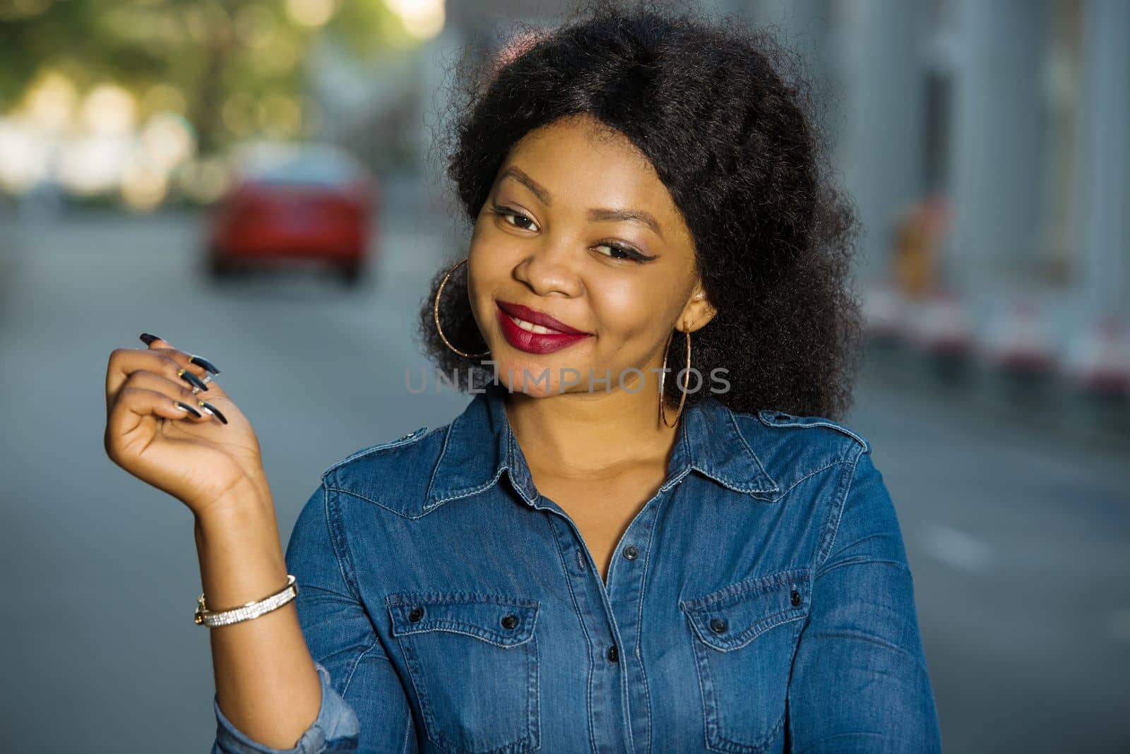 Cheerful girl wearing blue jeans shirt pointing a place with hand in the street