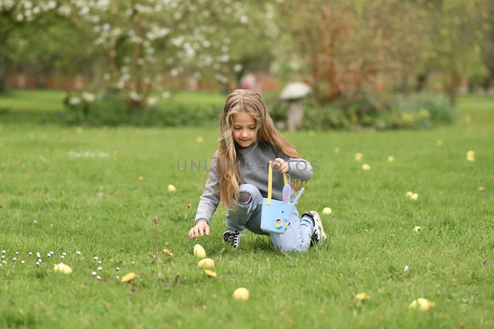 Girl collects the eggs in a basket Easter