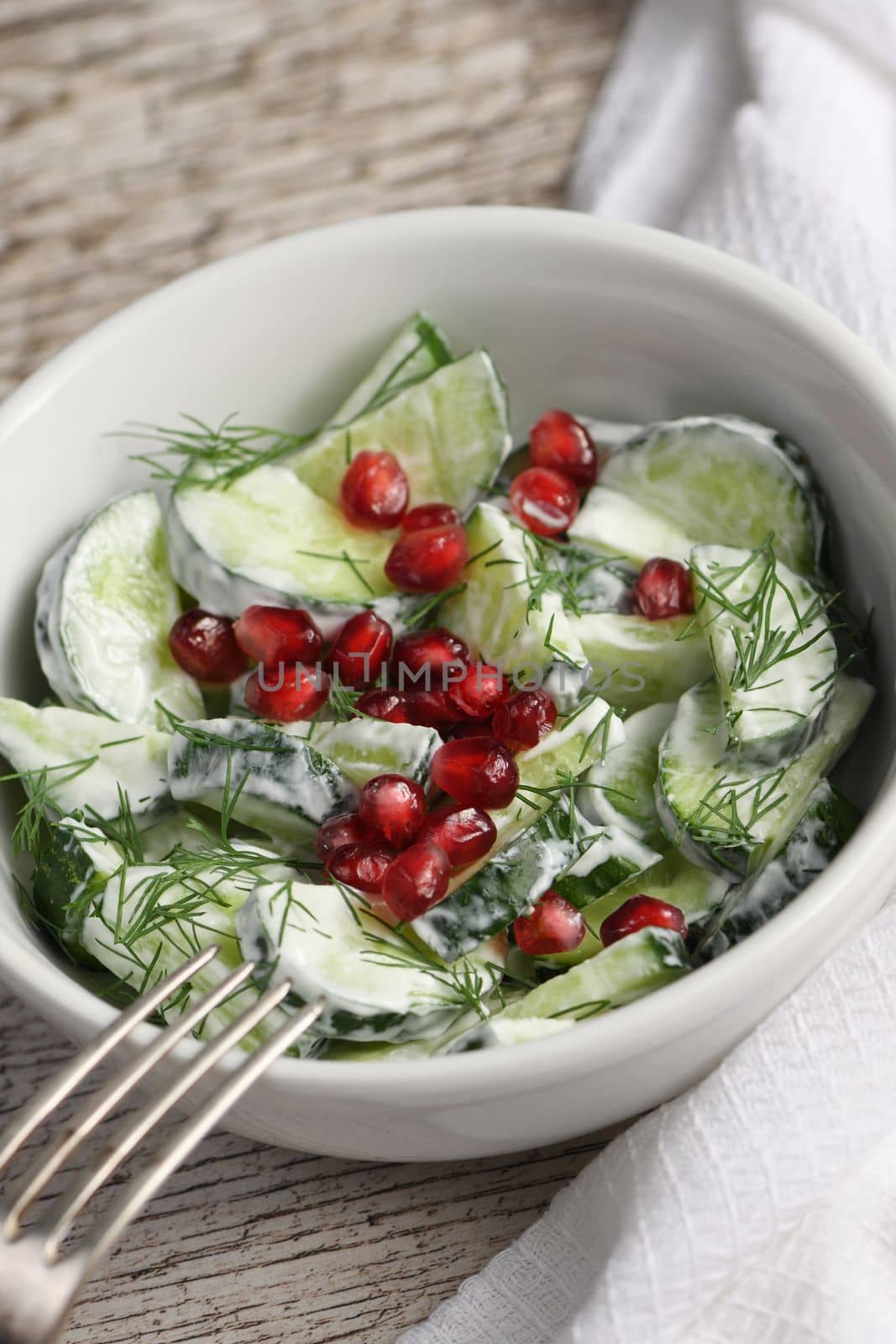 Fresh cucumber salad with dill and pomegranate kernels, in yoghurt sauce