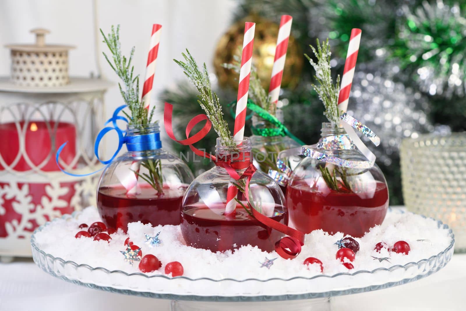 Gin with tonic and cranberry juice. The cocktail is full of festive Christmas flavors. Served in transparent bowls with a branch of rosemary.