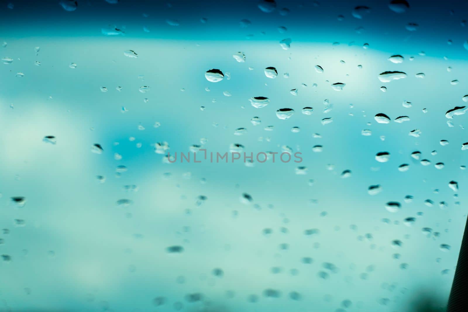 Raindrops on glass against blue sky. Window view background screensaver. Place for text banner.
