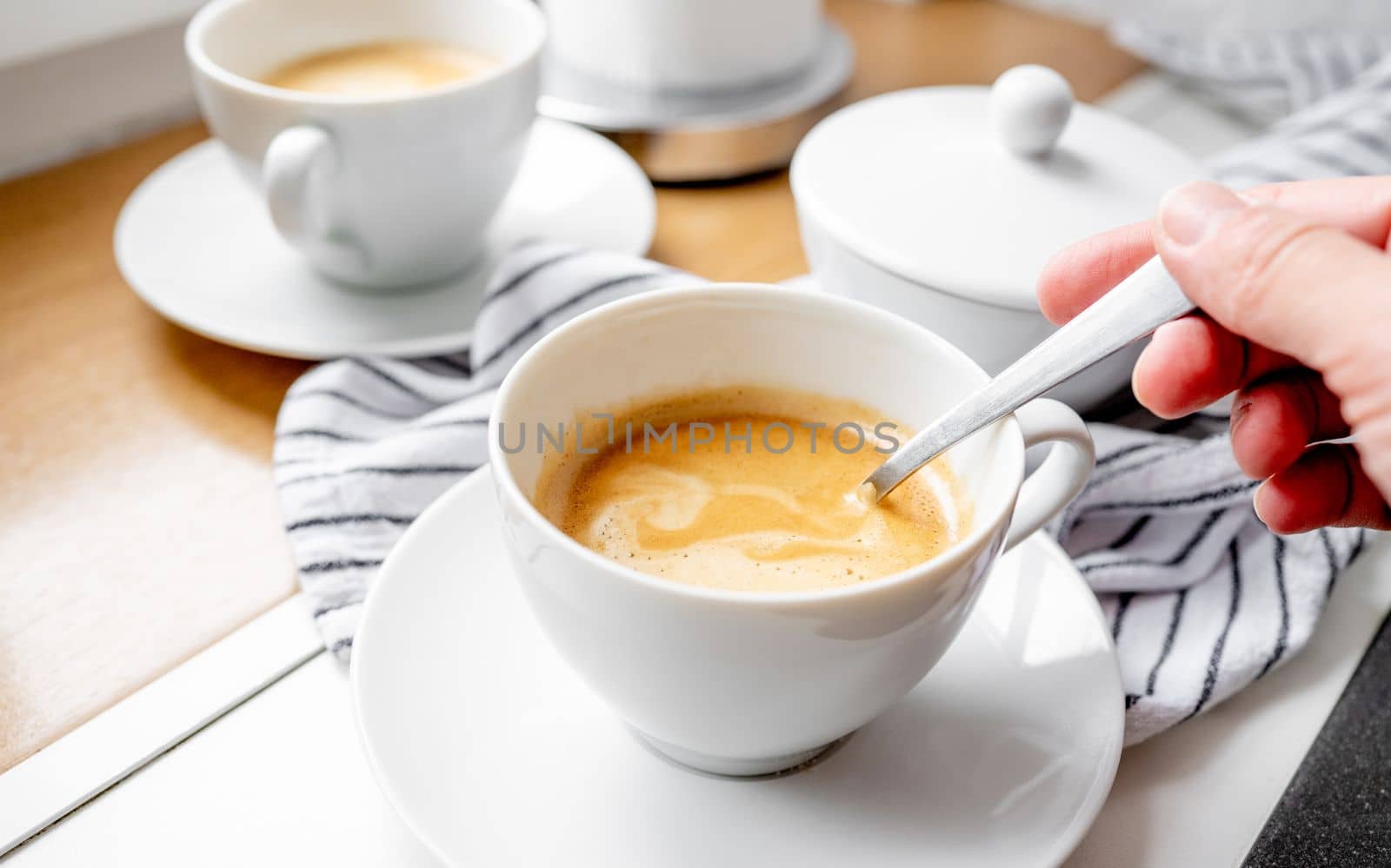 Girl stirs sugar in a cup of coffee. Close-up