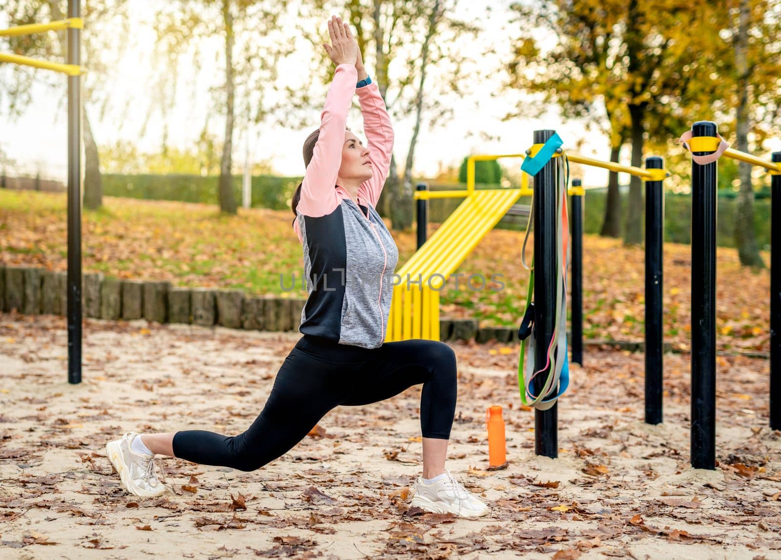 Fitness girl doing yoga workout pose outdoots in autumn time. Young woman exercising in park