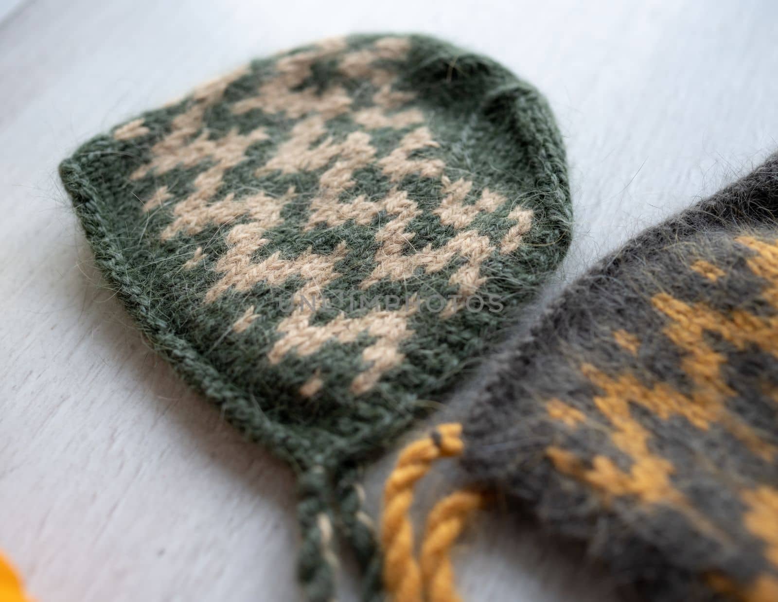 knitted newborn baby clothes composed on a wood table
