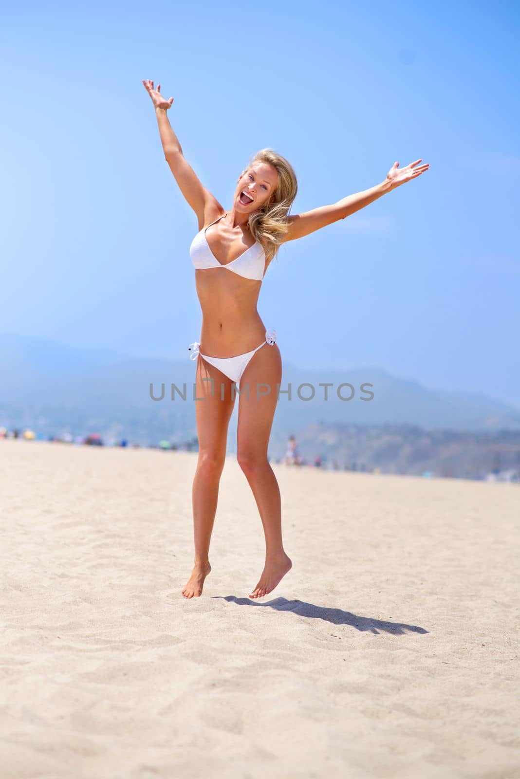 Sea, sun and summer fun. A gorgeous young blonde woman enjoying summer on the beach