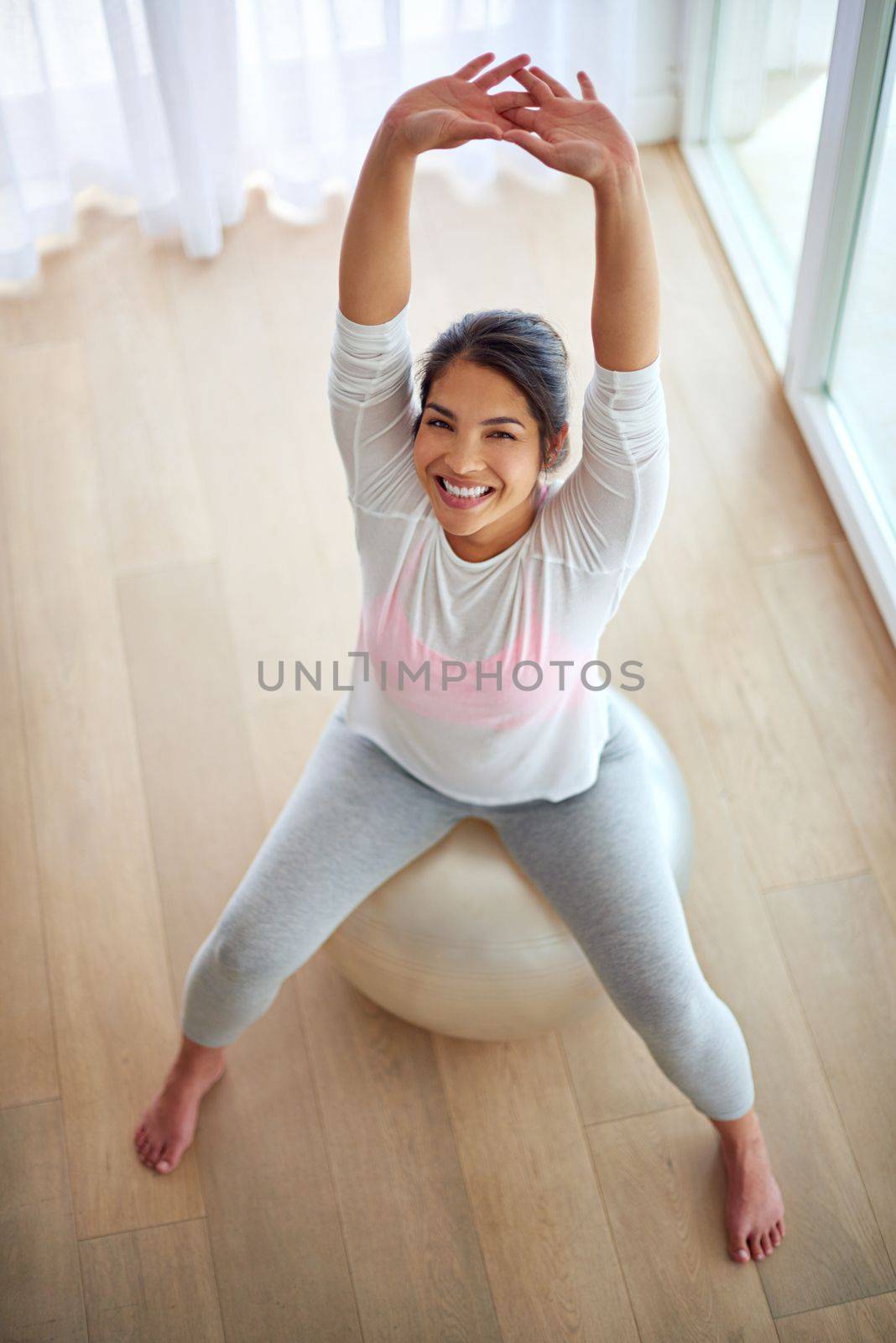 I can because I think I can. a young woman working out on a fitness ball. by YuriArcurs