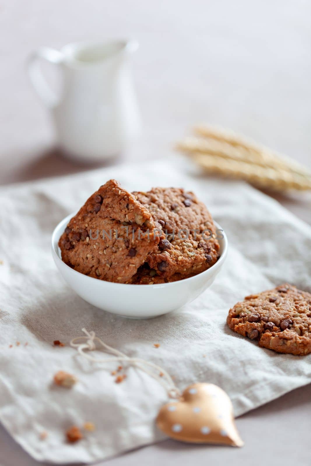 homemade cookies with cereal and seeds, bowl on a table, side view