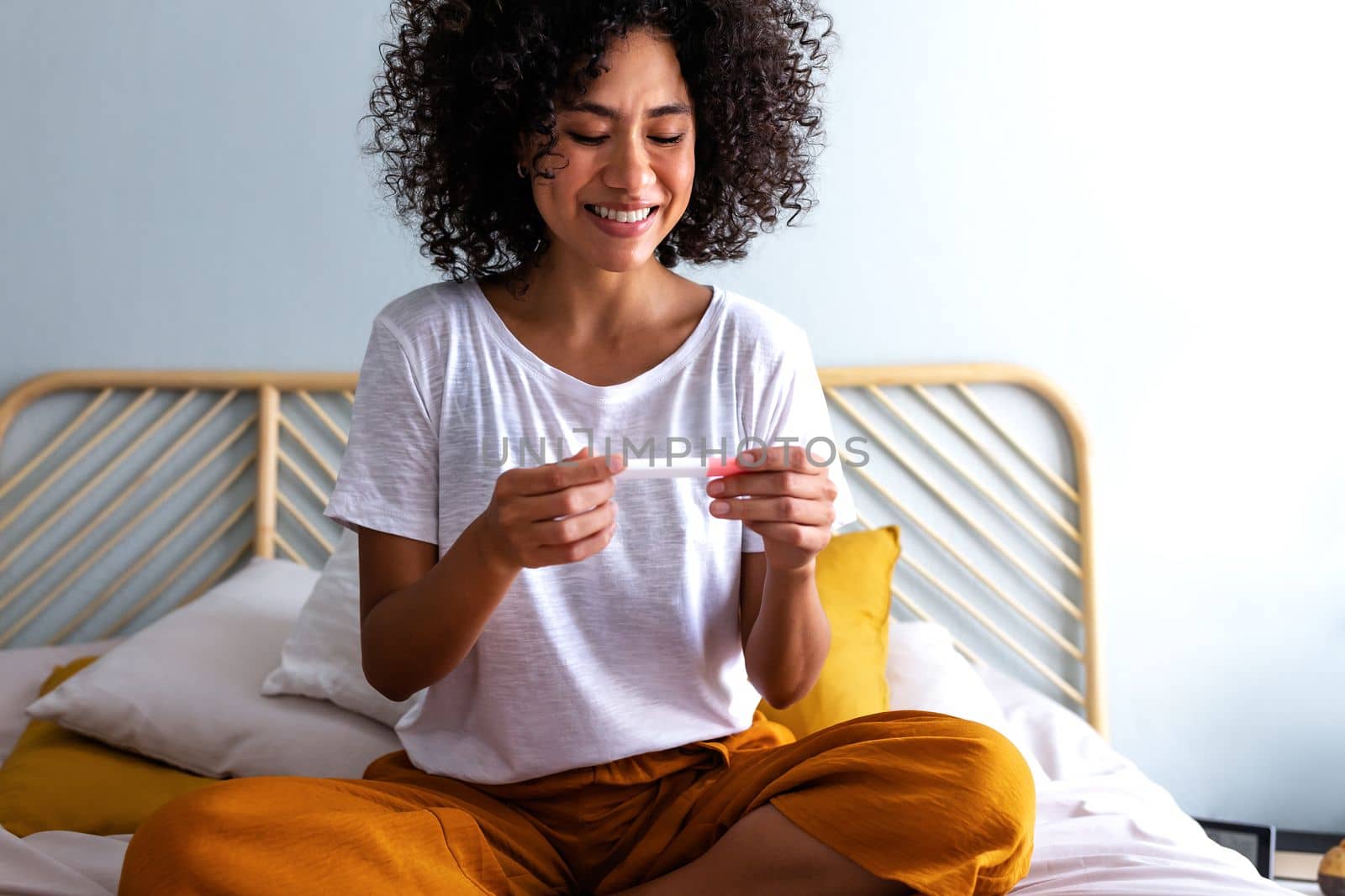 Happy young multiracial woman checking pregnancy test. Pregnancy concept.