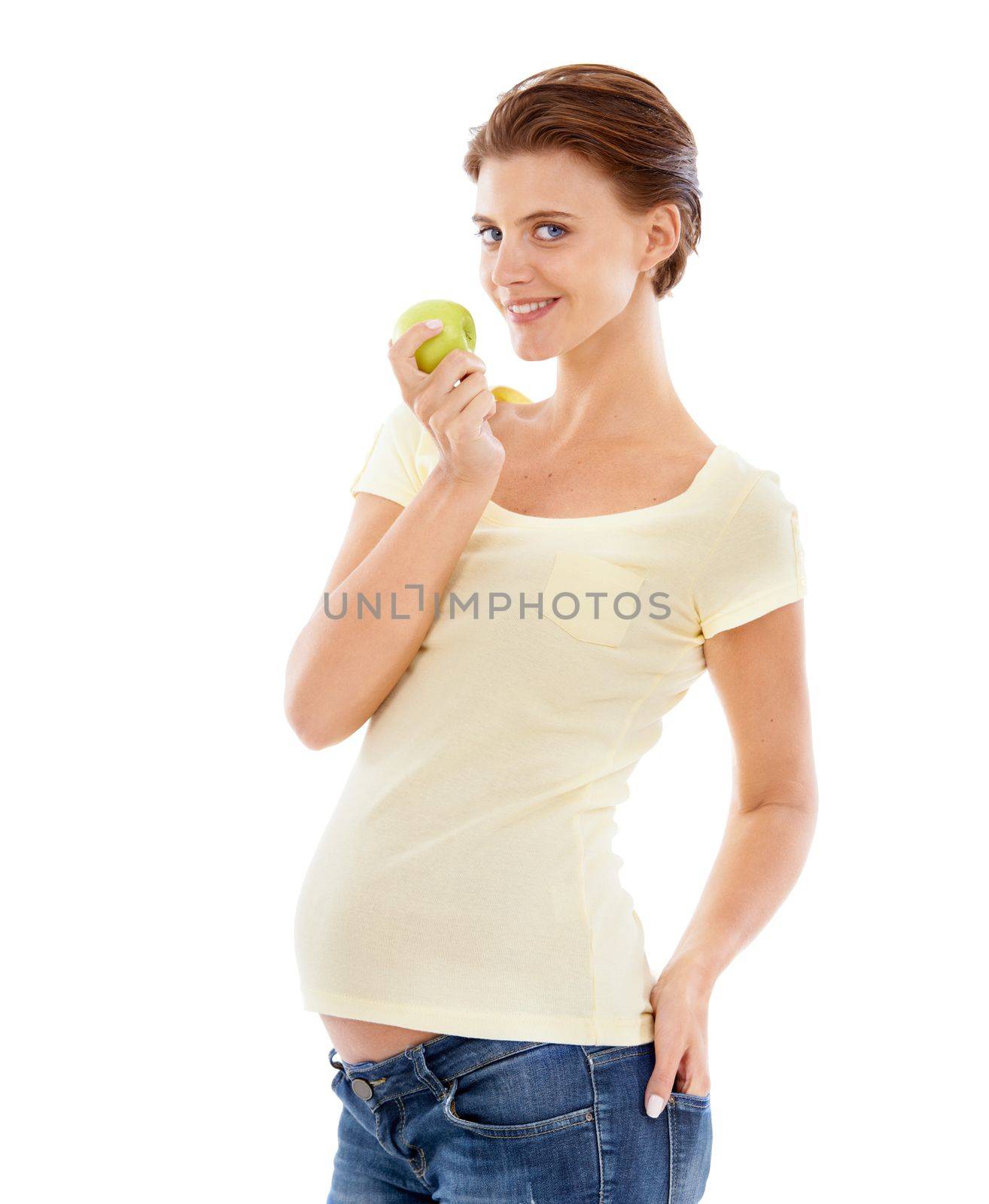 Eating for two now...A pretty pregnant woman holding a green apple while isolated on a white background