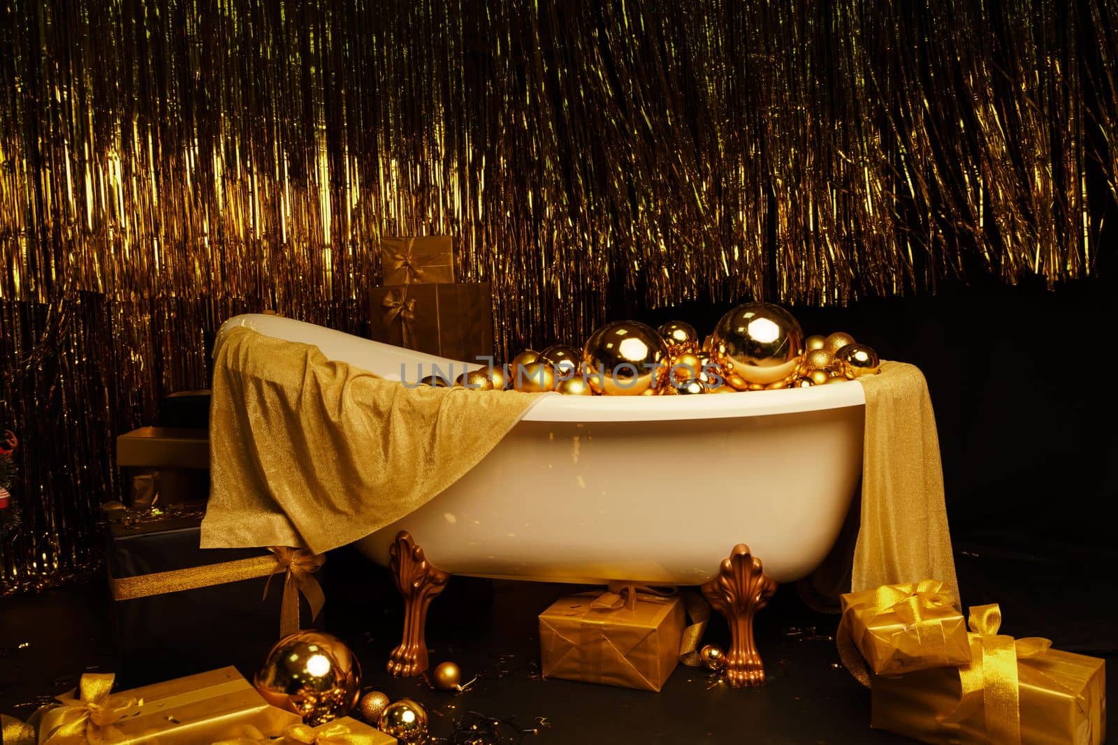 Bathtub full of golden balls. Vintage bright bathroom decorated with festive golden balls. New Year, Christmas bathroom interior