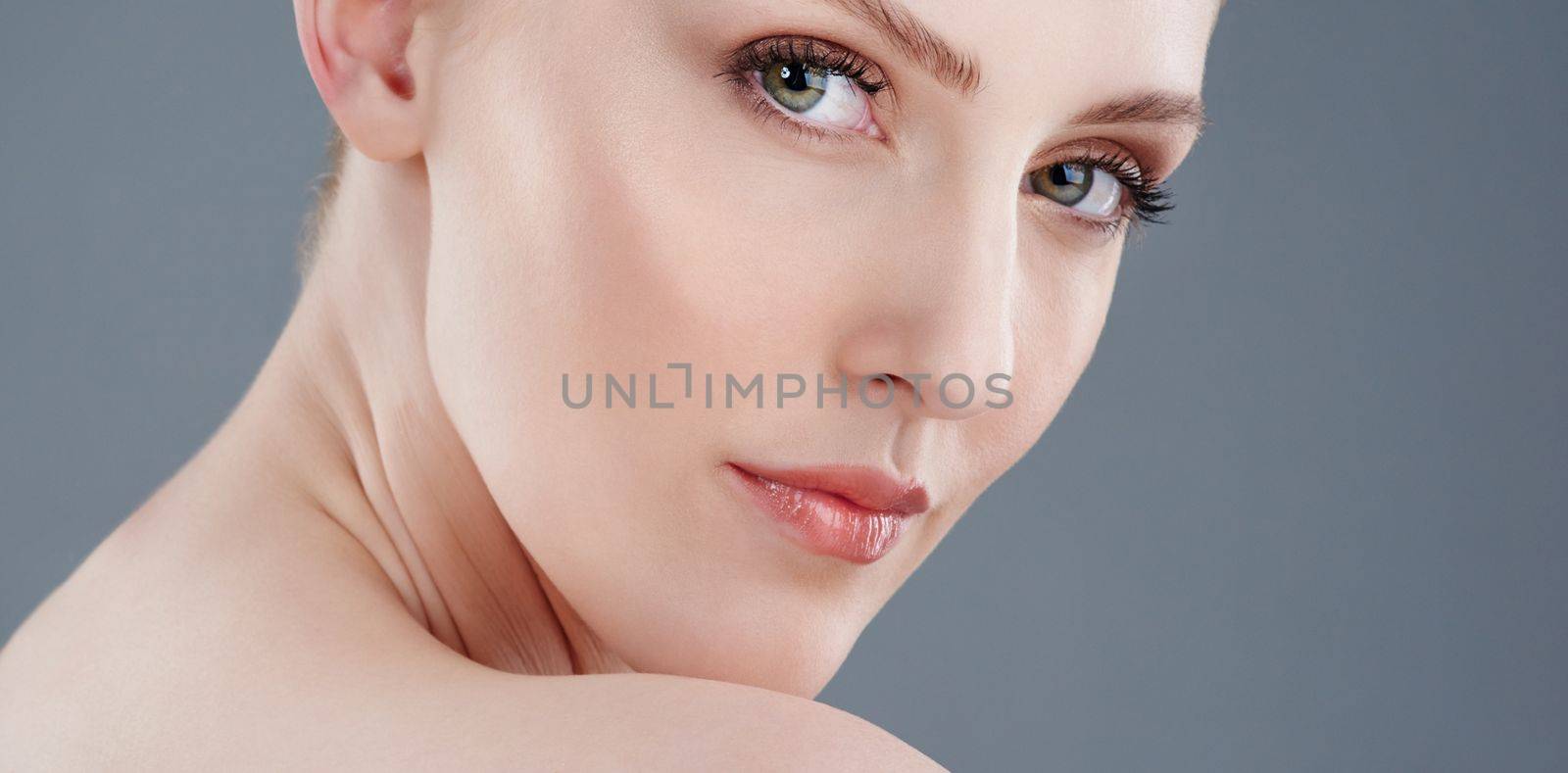 Beauty that turns heads. Studio portrait of a young woman with beautiful skin isolated on gray