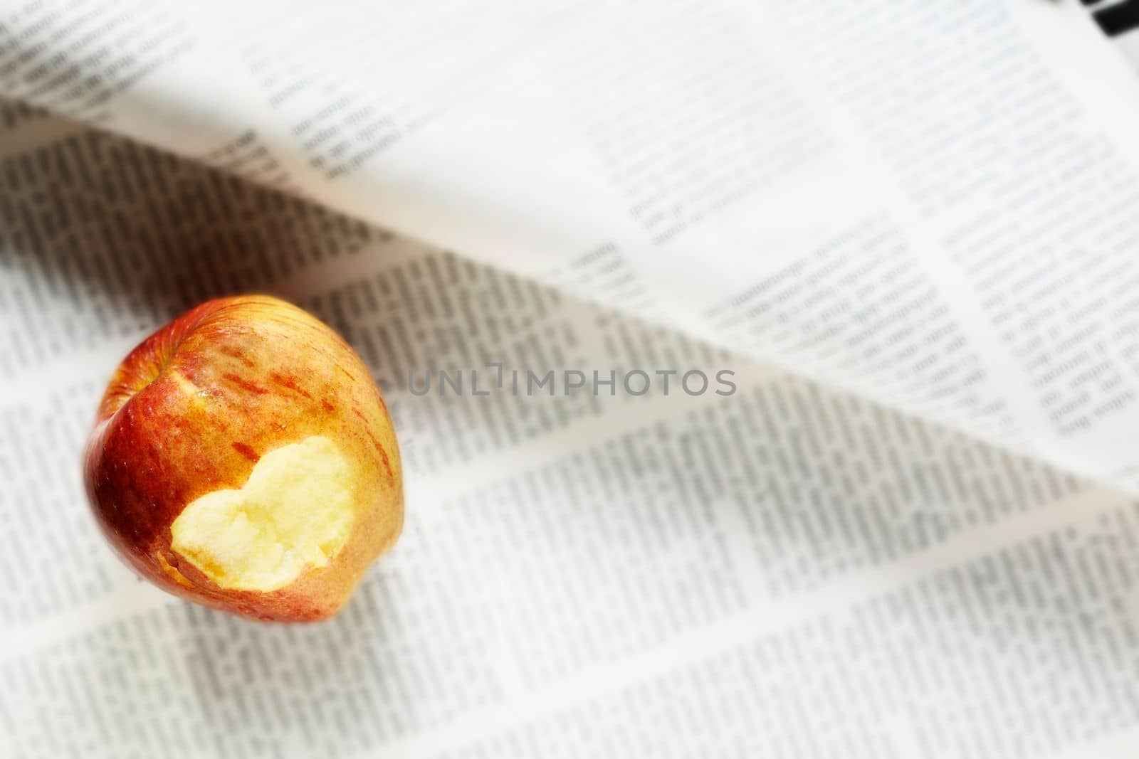 Eaten red apple on newspaper , take a break 