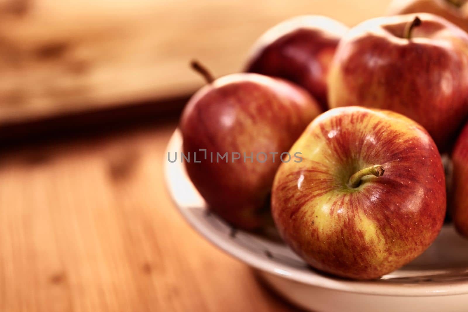 Fresh red apples  on plate on wooden table , healthy eating 