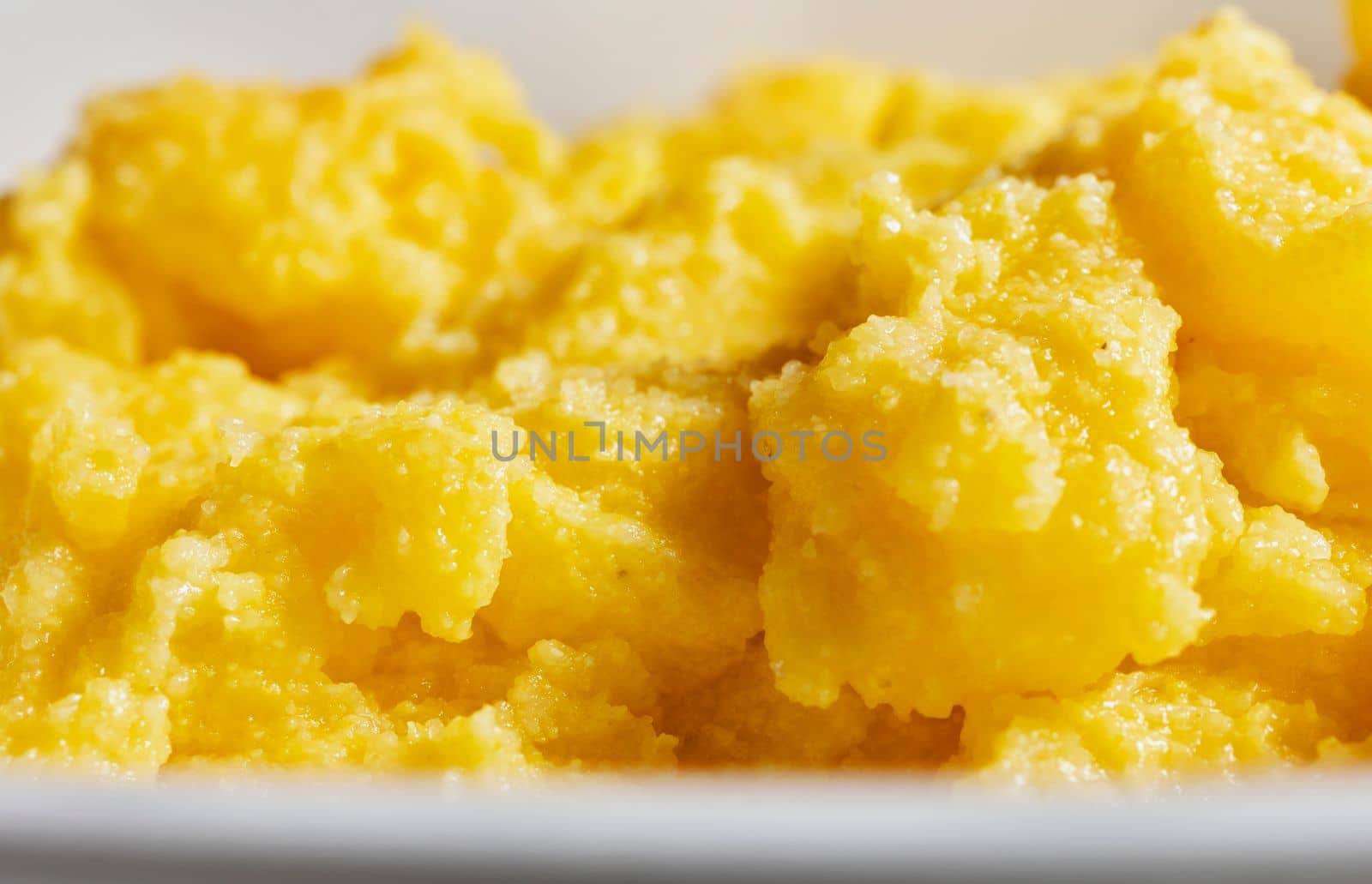 Plate with cooked yellow corn flour , polenta , traditional Italian food 