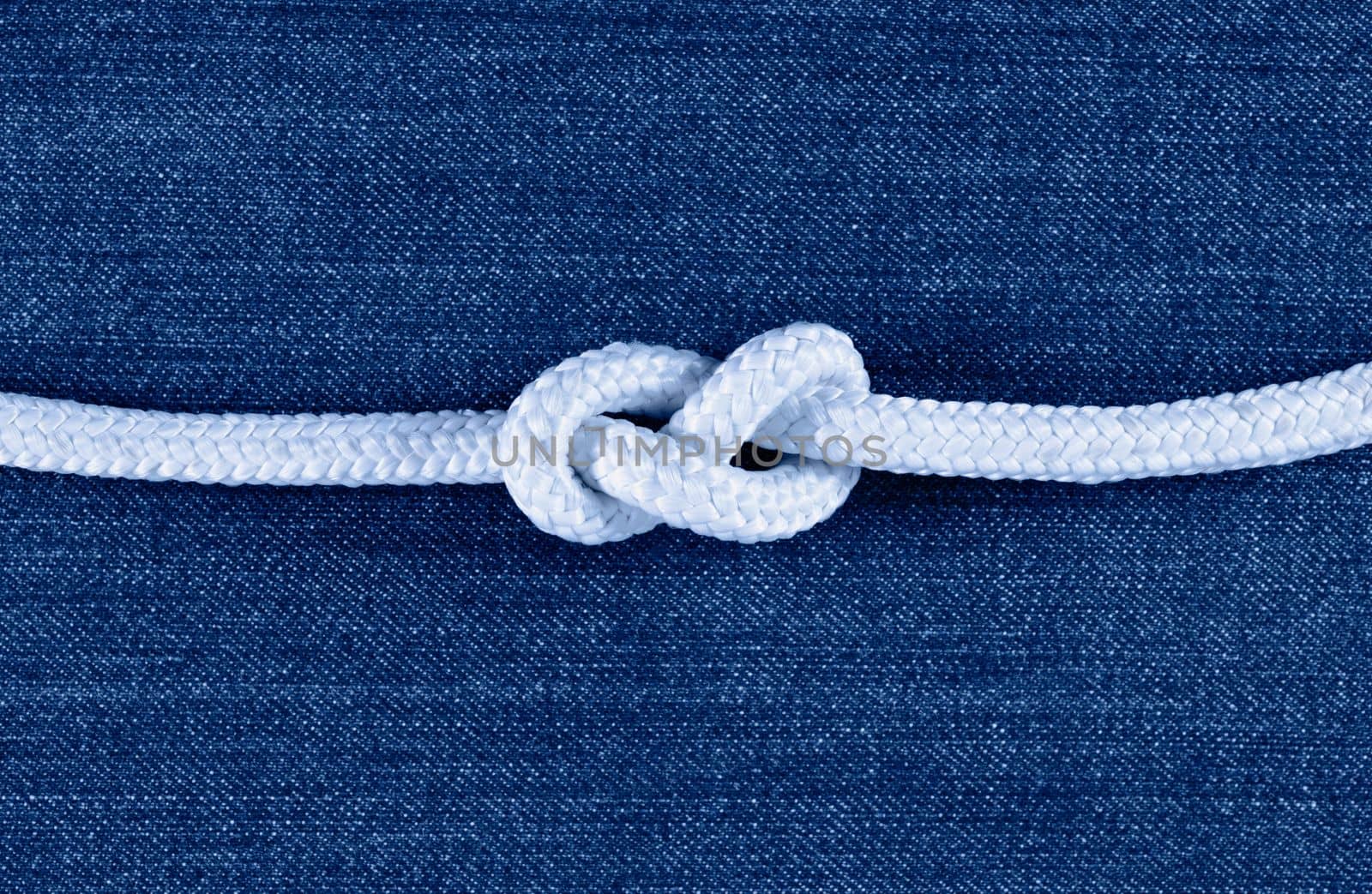 Tied white rope against blue background , nautical rope 