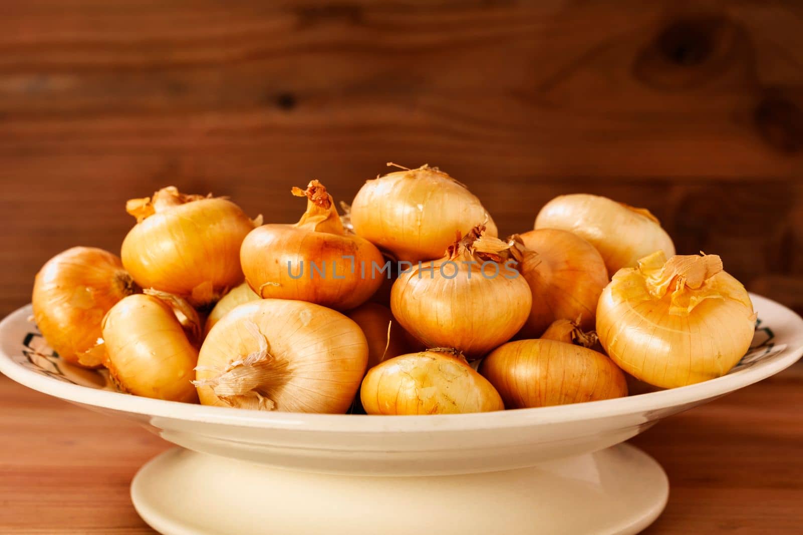 Uncooked onions in plate  by victimewalker