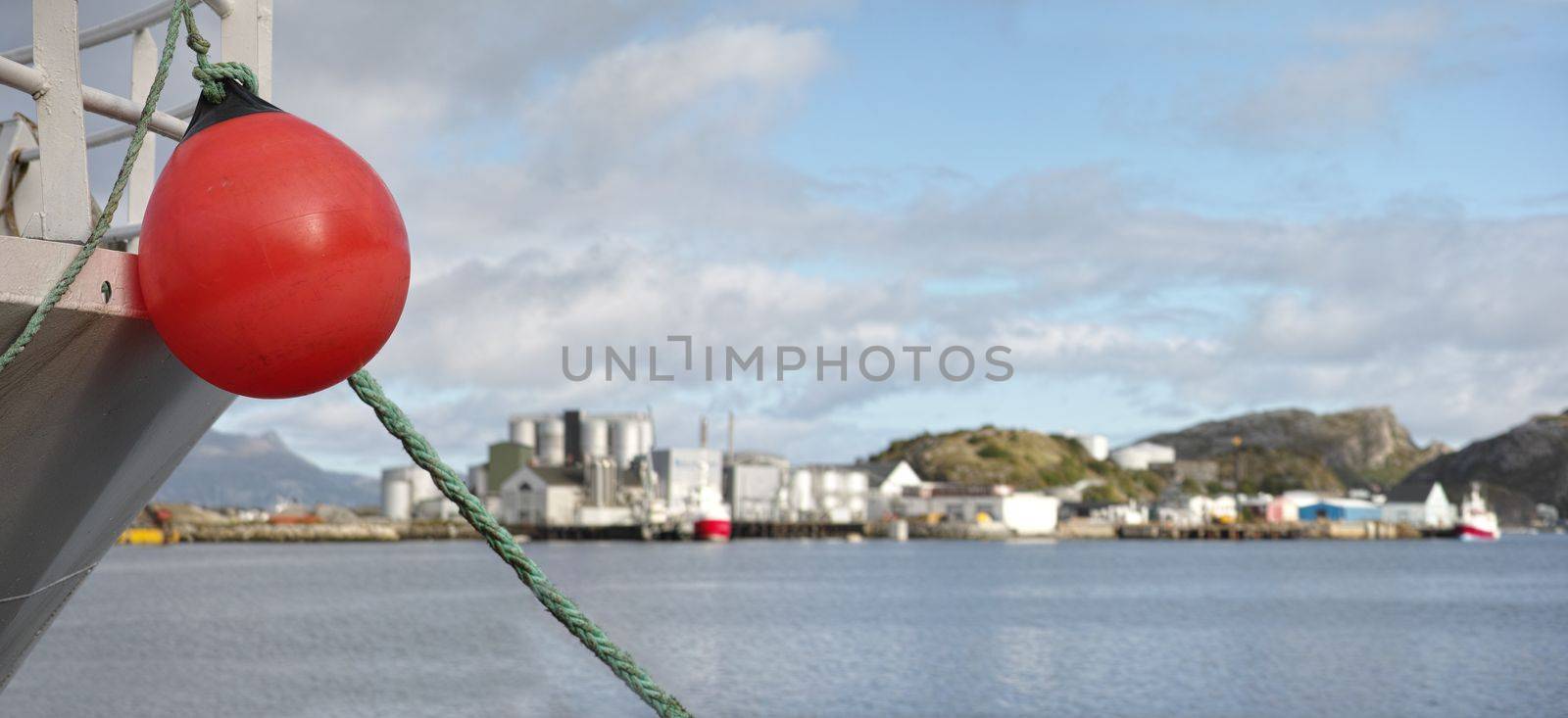 Buoy hanging off the side of a ship. A buoy hanging of the side of a boat with the harbour in the background - copyspace. by YuriArcurs