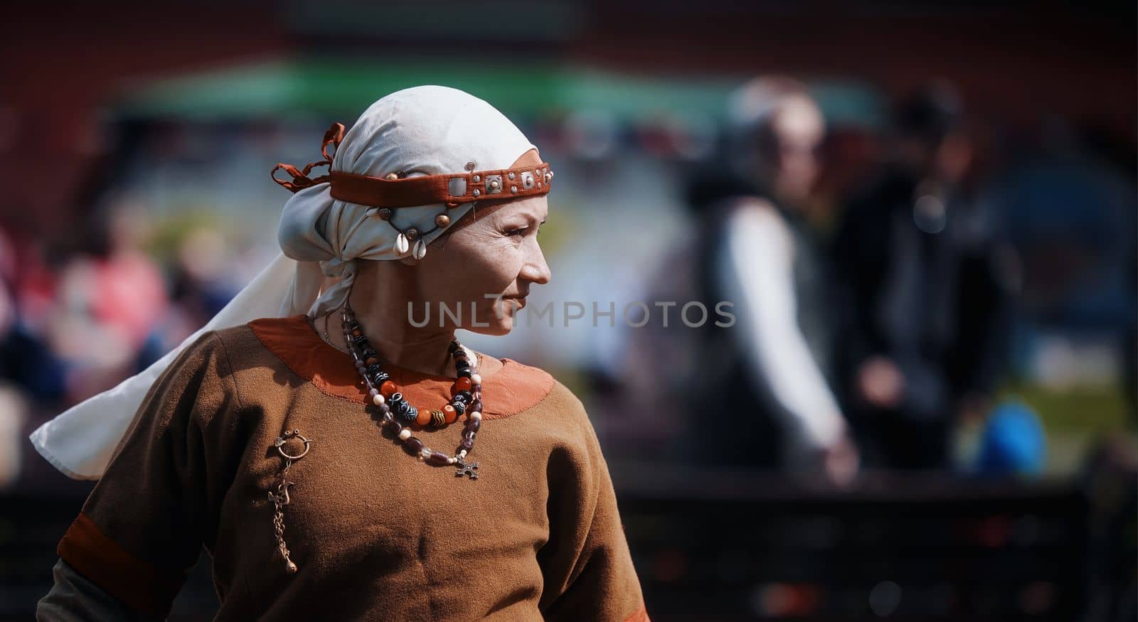 Medieval archery tournament. A woman shoots an arrow in the medieval castle yard. Woman in medieval dress with a wooden bow in her hands. historical reconstruction. 14.05,2022. Yoshkar-Ola, Russia.