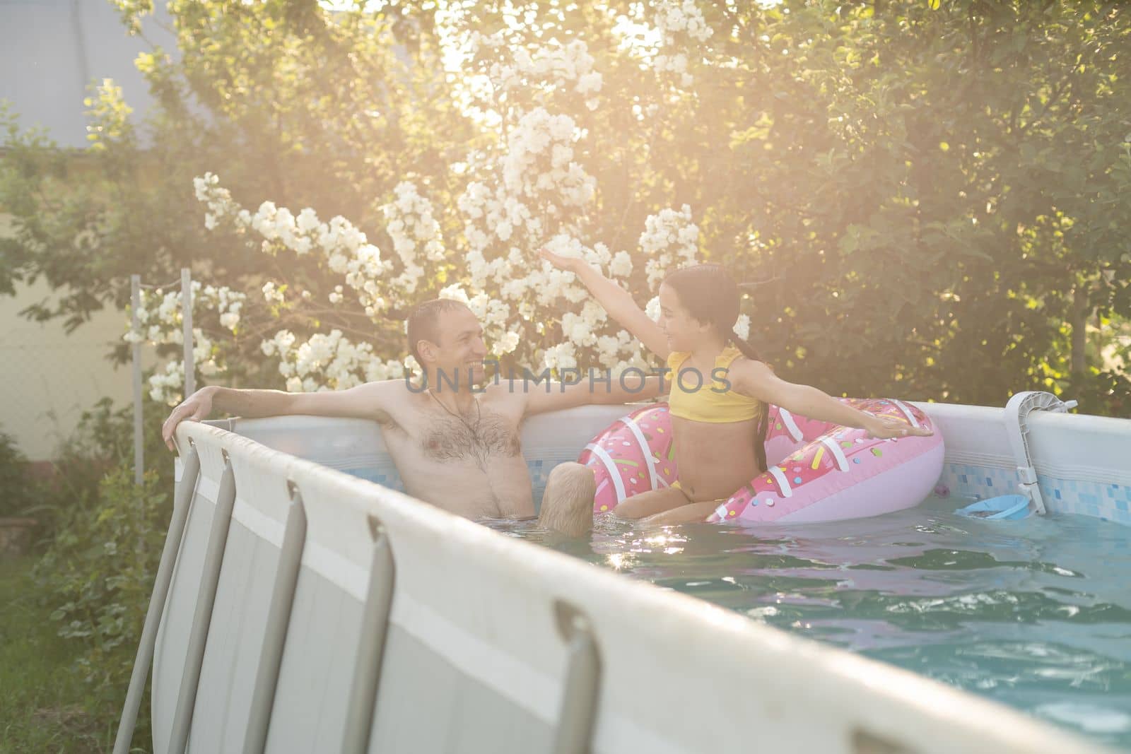 Father playing with his daughter in swimming pool.