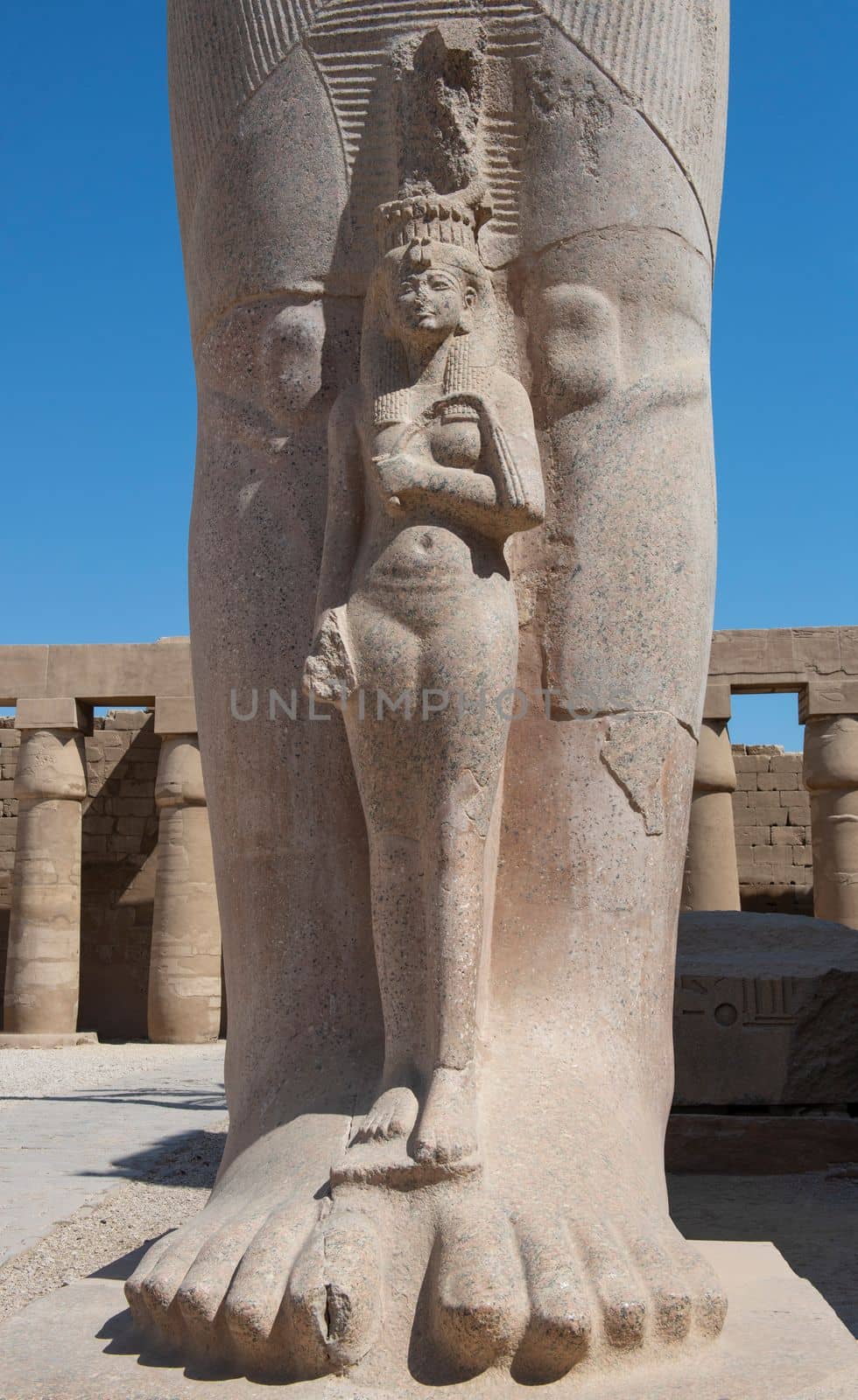 Large statue of Queen Nefertari at ancient egyptian Karnak Temple with Ramses II in courtyard area