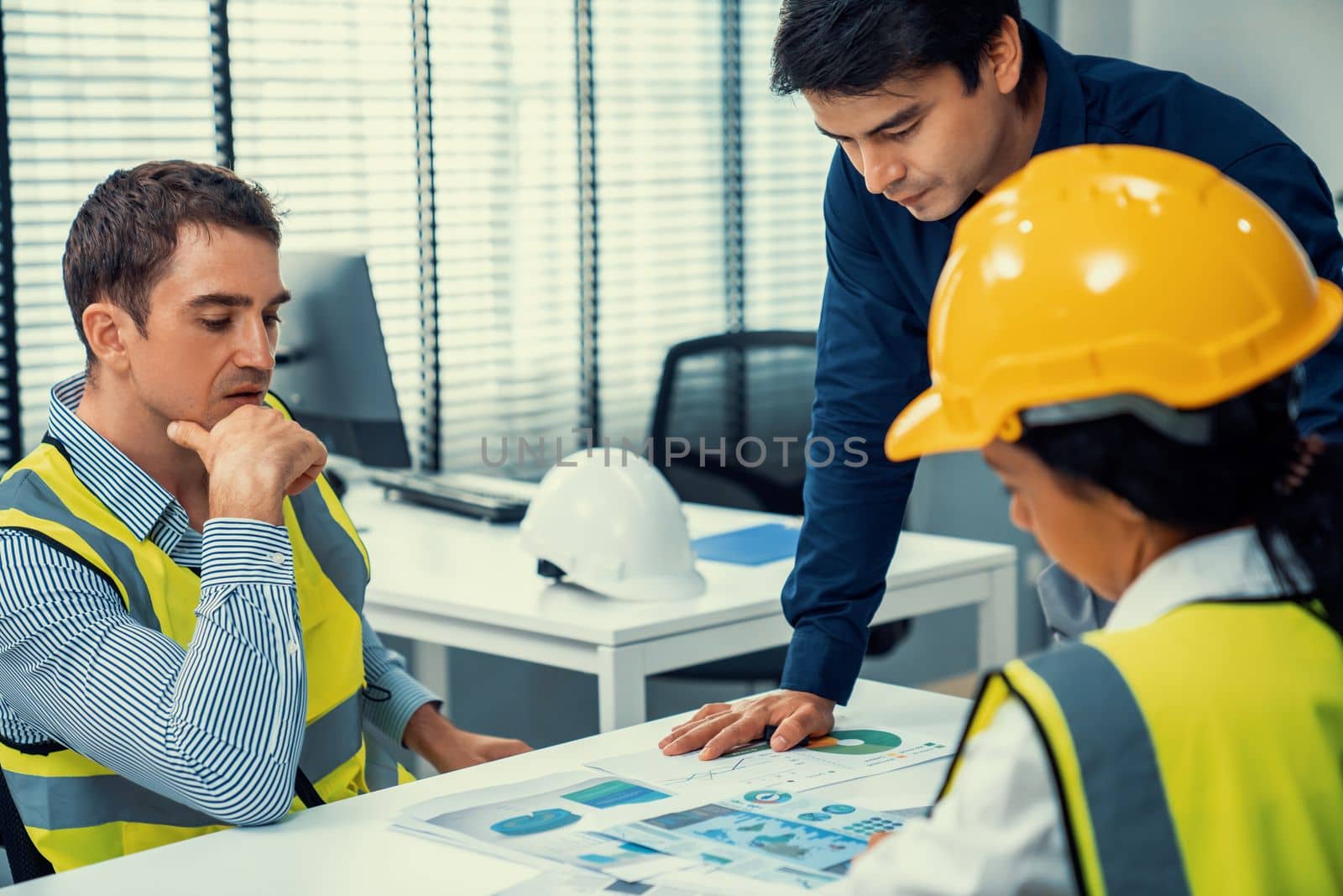 Engineers and competent employer discussing plans and blueprints together with tablet in the office. Concept of team contribution of ideas for engineering project.