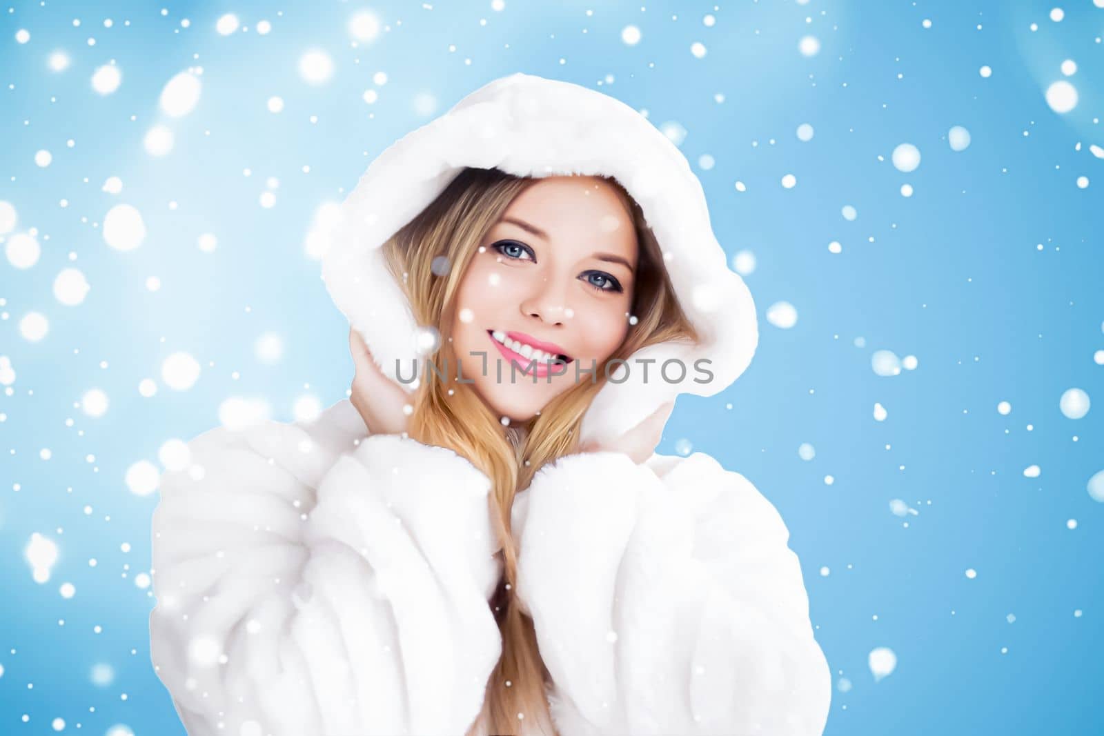 Happy holidays, beauty and winter fashion, beautiful woman wearing white fluffy fur coat, snowing snow on blue background as Christmas, New Year and holiday lifestyle portrait style