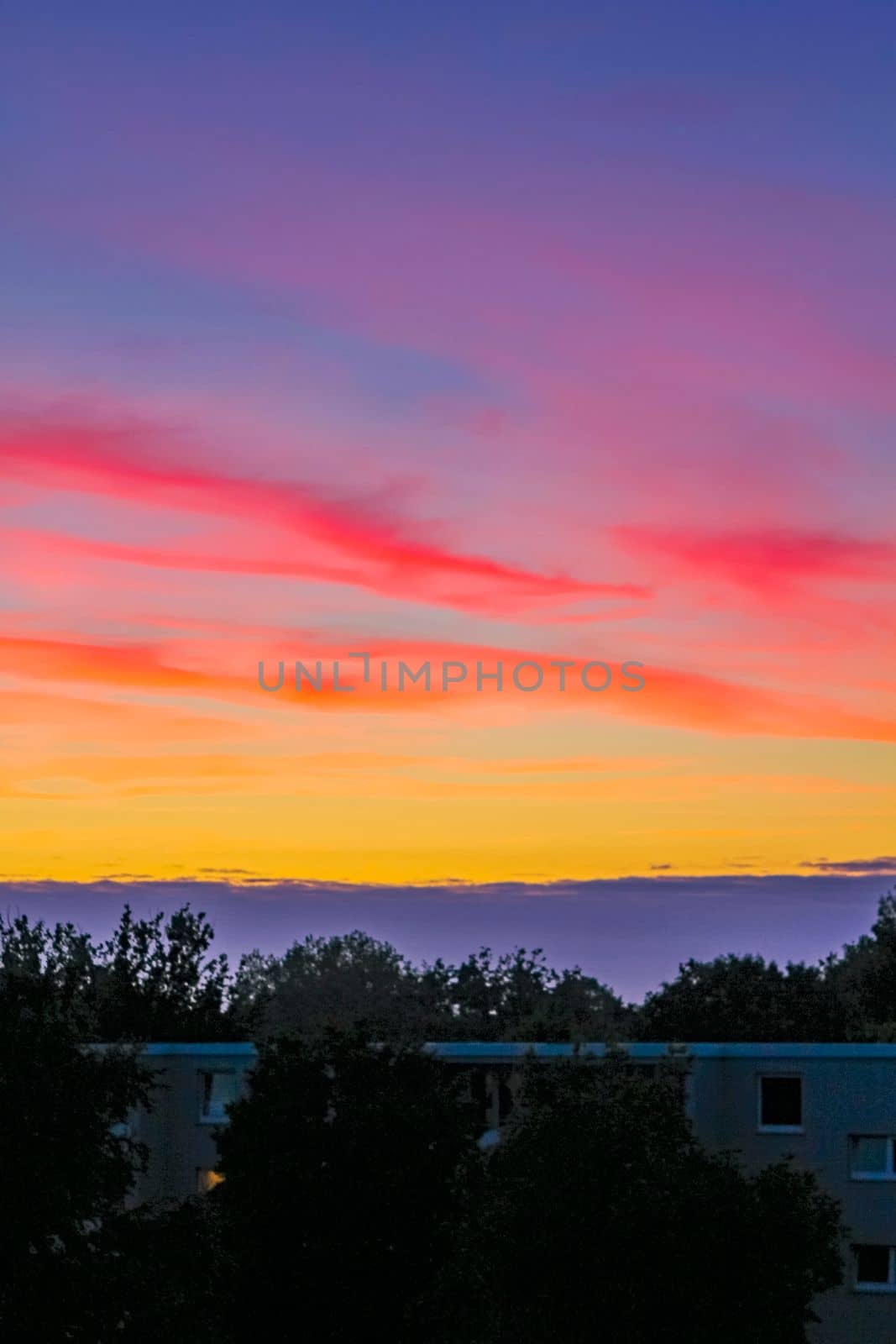 Amazing colorful pink violet orange red yellow blue and purple sunset sky panorama in Leherheide Bremerhaven Germany.