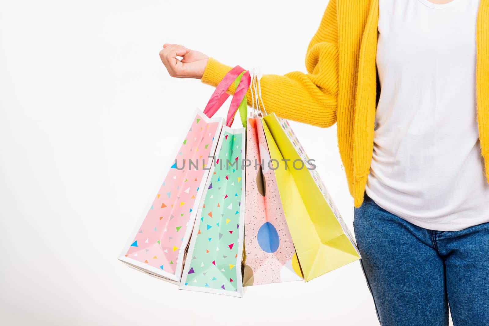 Happy woman hand she wears yellow shirt holding shopping bags multicolor, young female hold many packets within arms isolated on white background, Black Friday sale concept