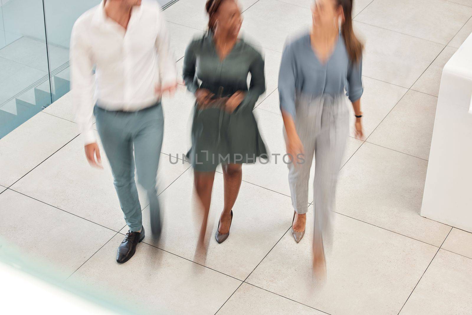 Walking, blurred motion and office with a business man and woman team at work together from above. Working, collaboration and moving with a male and female employee group taking a walk at speed.