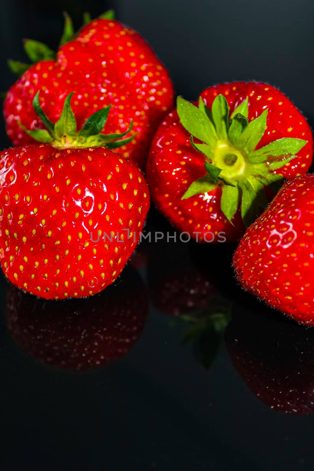 Strawberries with noble black background glass table Germany. by Arkadij