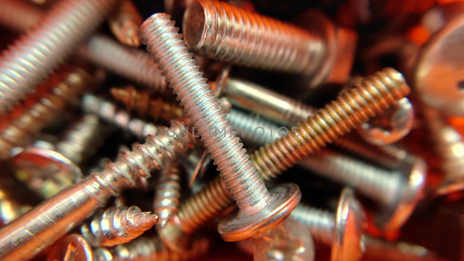 A bunch of bolts screws nuts of different sizes .Macrophotography.Texture or background.Selective focus.