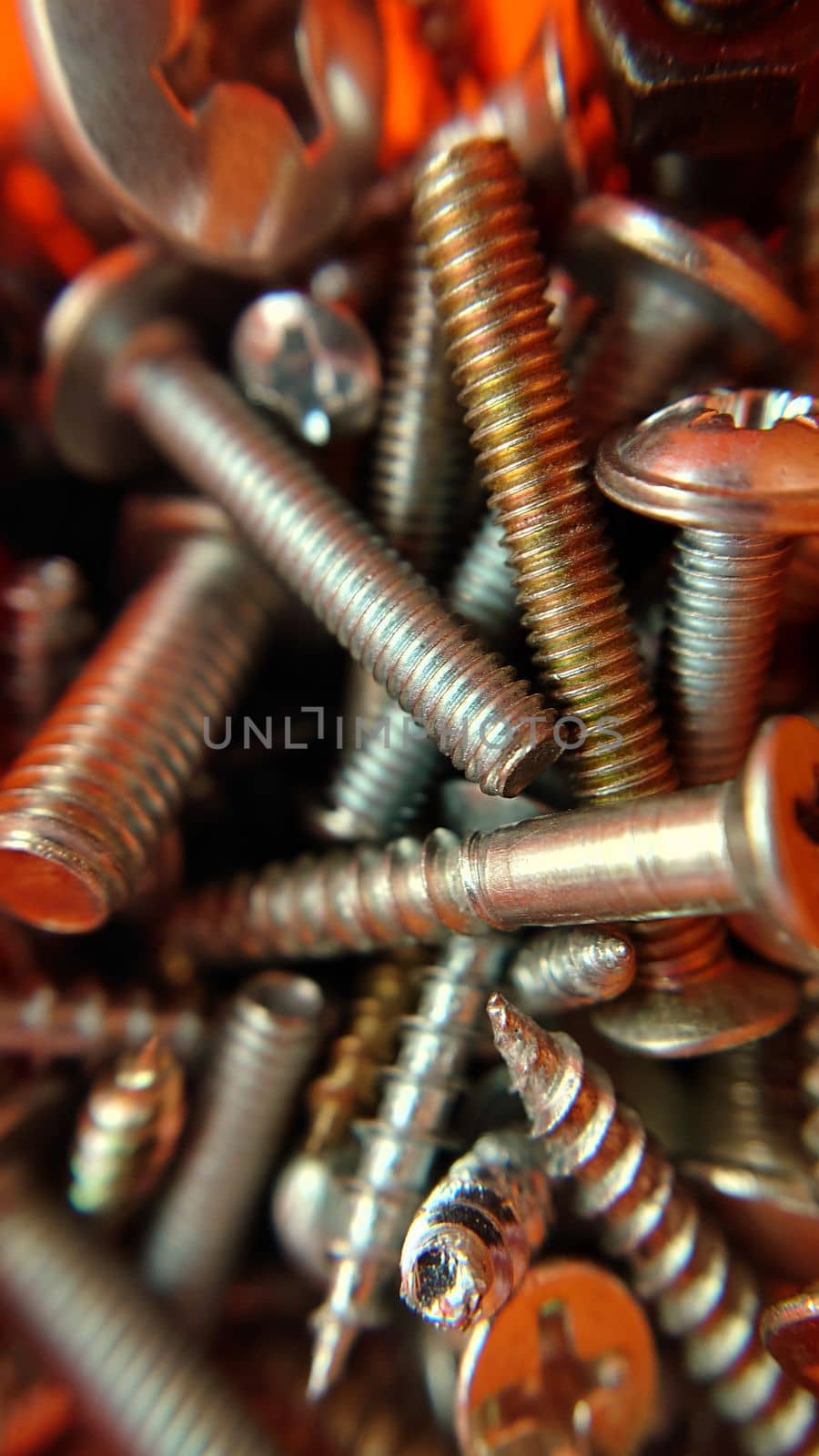 Randomly lying bolts screws nuts top view.Macrophotography.Texture or background.Selective focus.
