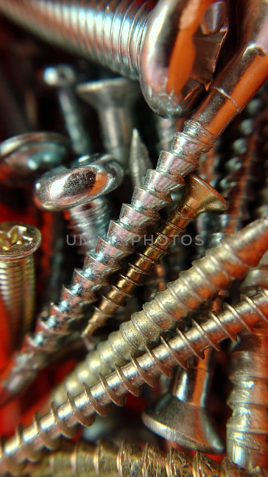 Screws bolts of different sizes and colors are randomly placed. Macrophotography.Texture or background.Selective focus.
