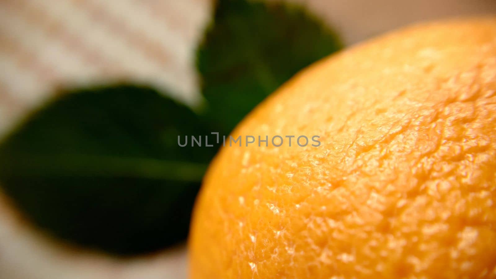 Top view of an orange with green leaves leaves close-up.Macro photography.Texture or background.Selective focus.