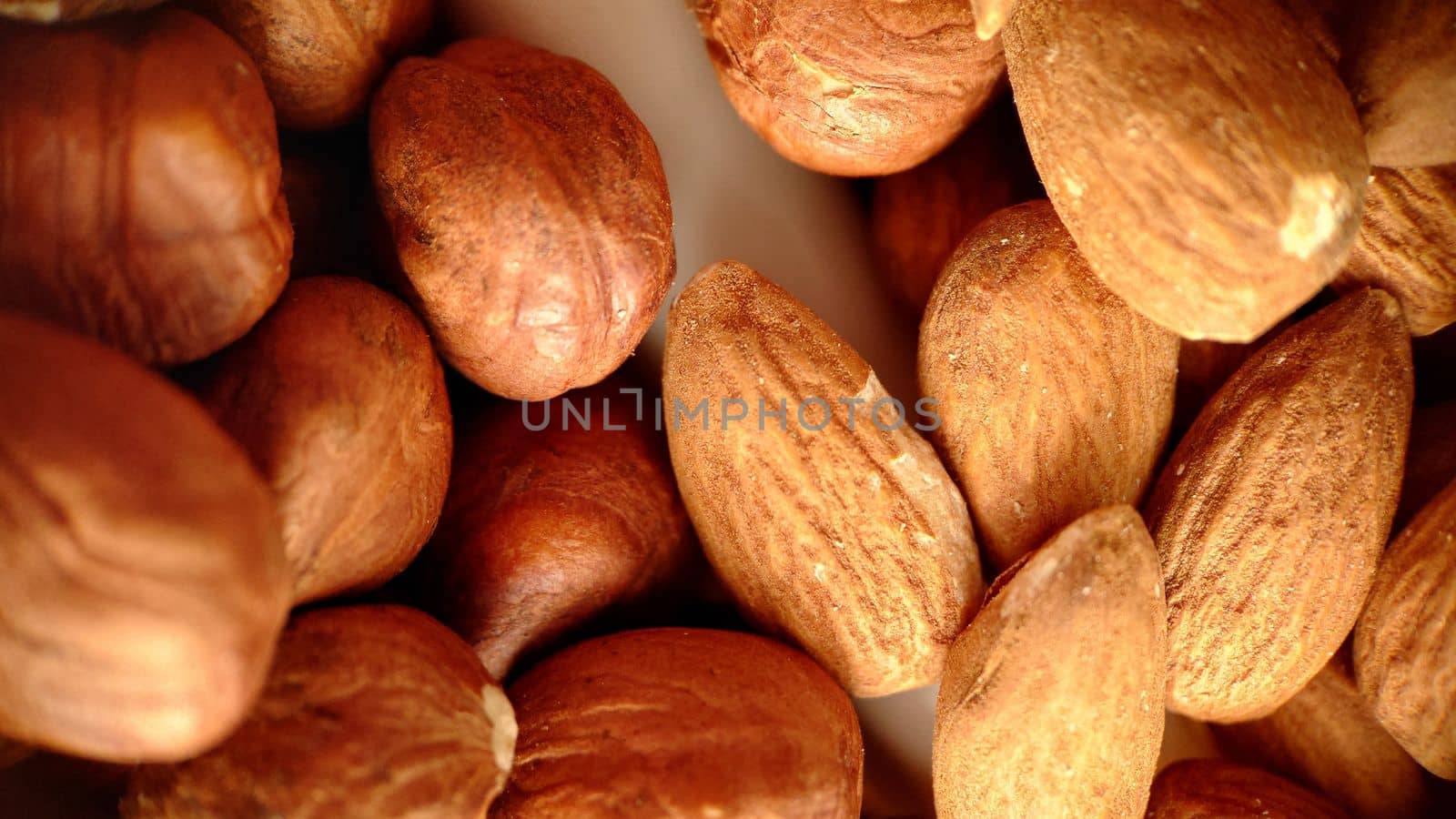 A mixture of hazelnuts and almonds in selective close-up focus.Macrophotography.Texture or background. Selective focus.