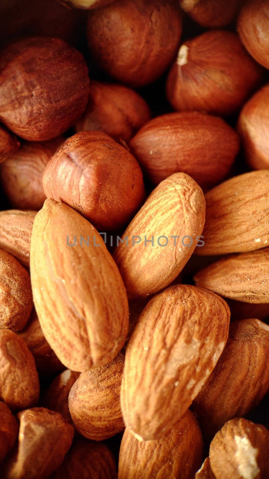 A mixture of hazelnuts and almonds in selective close-up focus.Macrophotography.Texture or background. Selective focus.