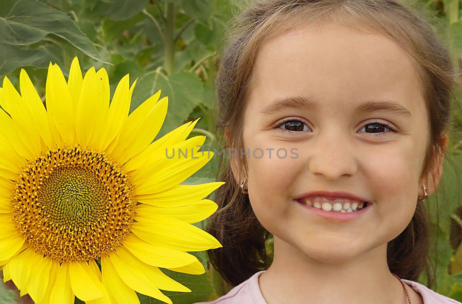 A girl with a smile stands next to a yellow sunflower by Mastak80