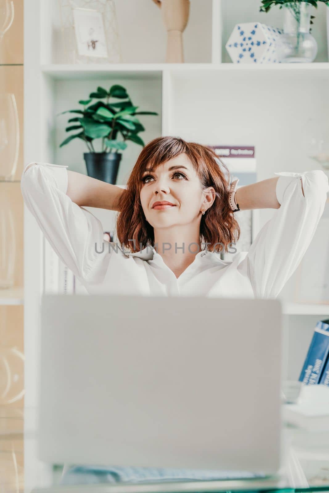 Office laptop woman. Calm smiling businesswoman relaxing on comfortable office chair hands behind head, happy woman resting in office satisfied after work, enjoying break, peace of mind, no stress by Matiunina