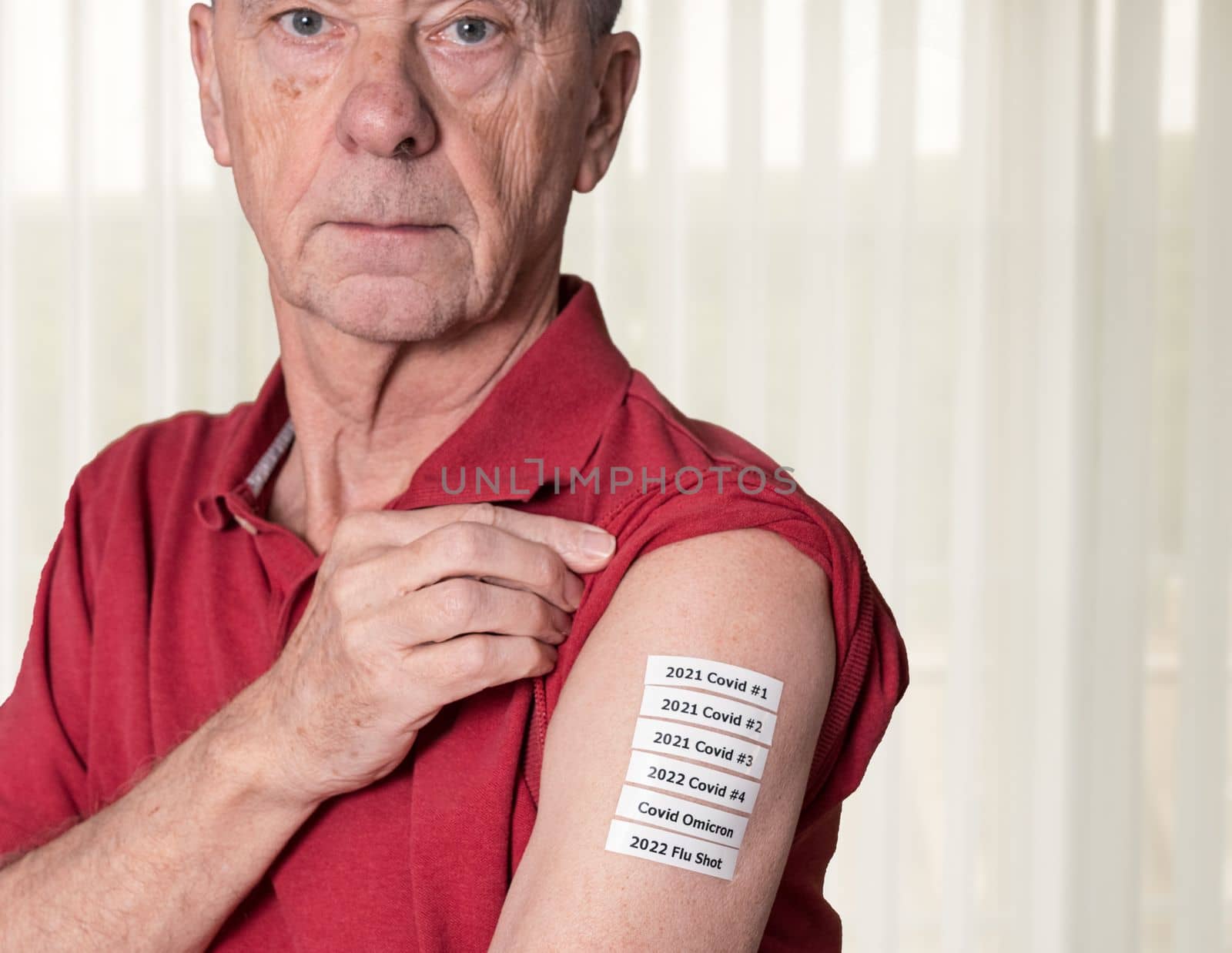 Senior man showing all the Covid and flu vaccinations in his arm by steheap