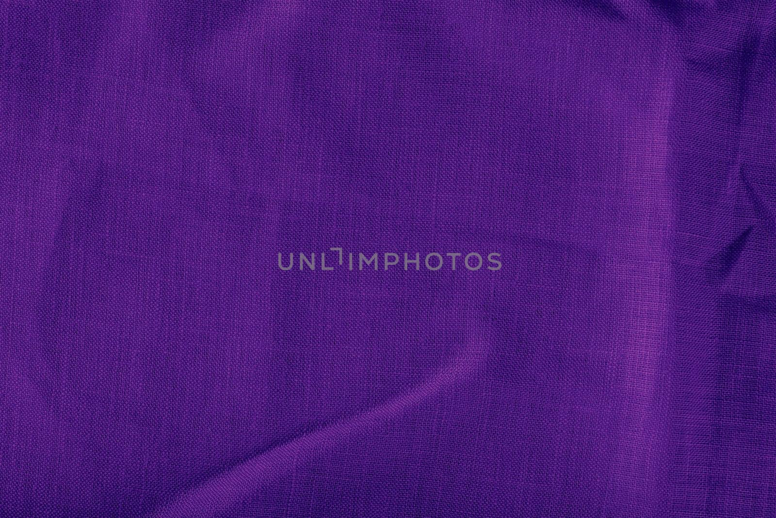 Purple linen fabric. Texture of crumpled linen fabric in folds close-up