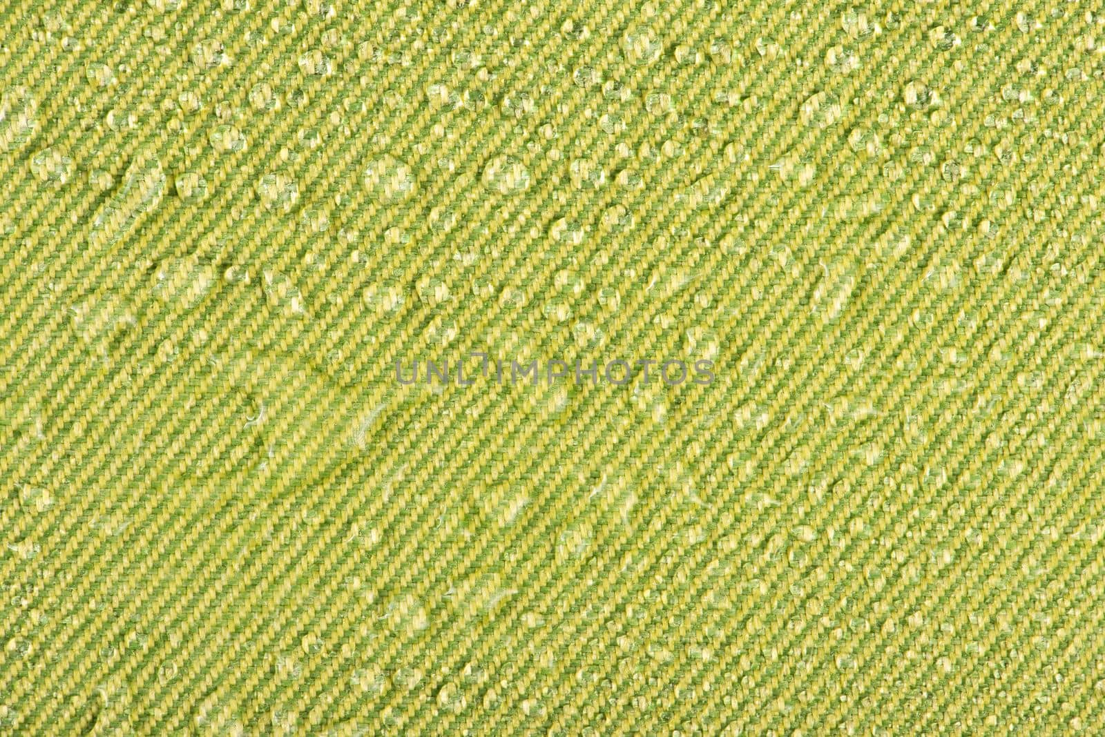 Waterproof clothing or upholstered furniture made from waterproof textiles. Drops of water on green textiles with water-repellent properties