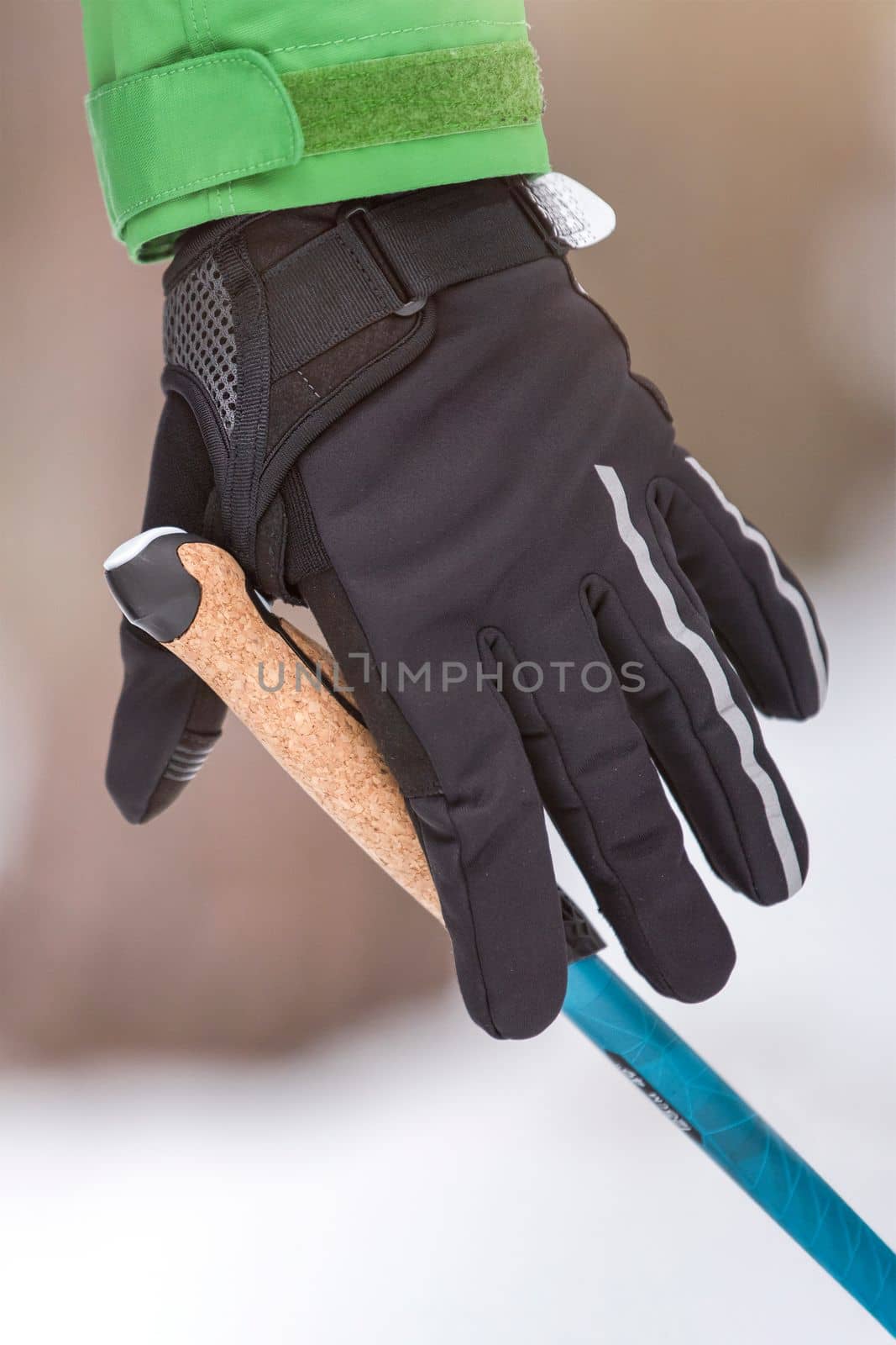 Nordic walking. Healthy lifestyle, outdoor sports in winter. A man's hand squeezes the handle of a cane for Nordic walking. Attach a stick to your hand.