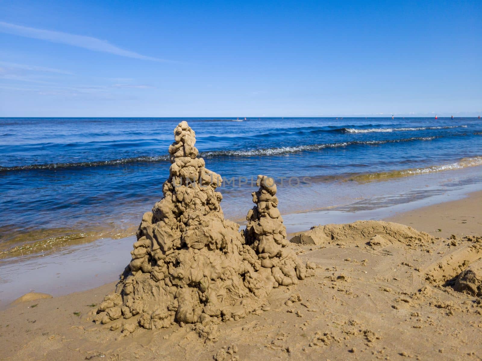 Built House sand castle with towers on the south shore of the sandy beach blue sea.